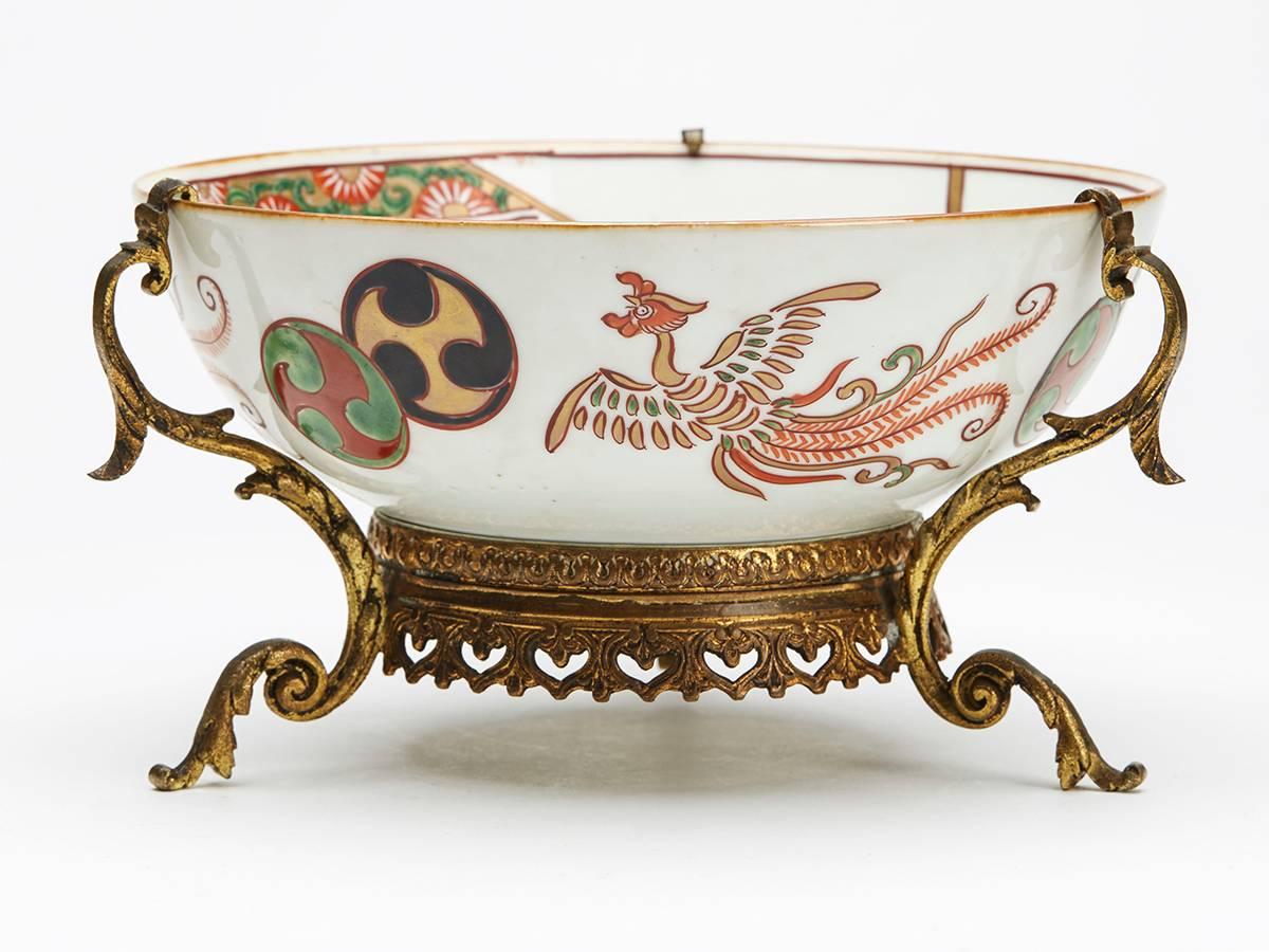 A very fine antique Japanese Meiji painted Arita bowl painted with exotic birds and man painted to the outer rim and with a figure to the inside within a decorative border. The porcelain bowl is mounted in an ornate ormolu stand and is not marked.