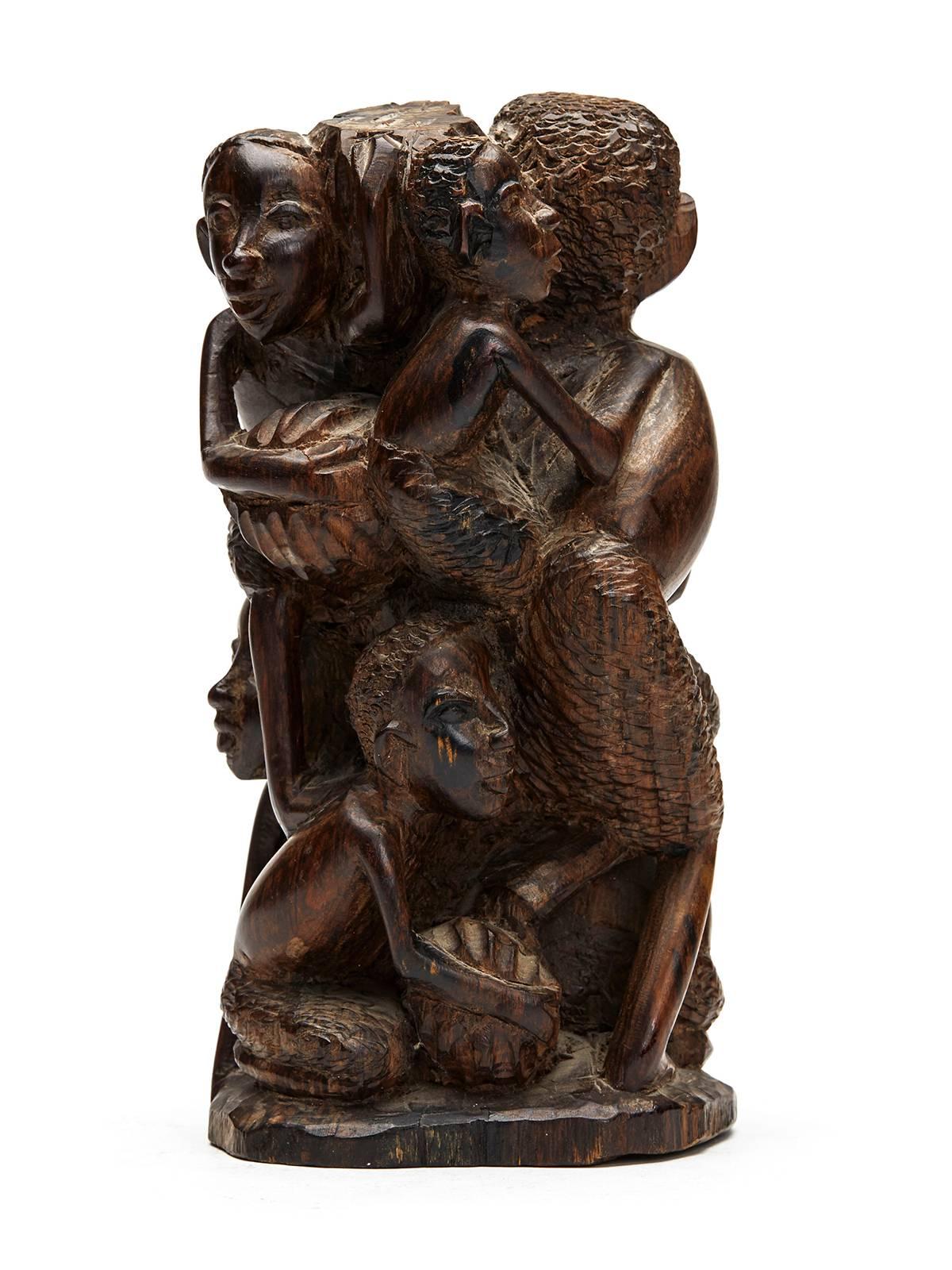 A very fine vintage African hand-carved figure group of a man and five boys gathering fruit. Carved from a solid block of wood the group is well carved with the man holding fruit in both arms with the boys gathered around his side. 

Provenance: