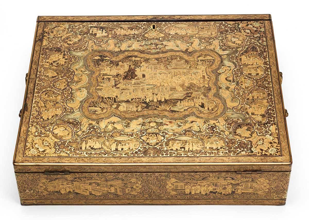 An exceptional and rare antique Chinese lacquer writing box, the lift up cover elaborately decorated with a central figural scene set within a scrolling dragon surround along with small vignettes. The box has handles to either side with the sides