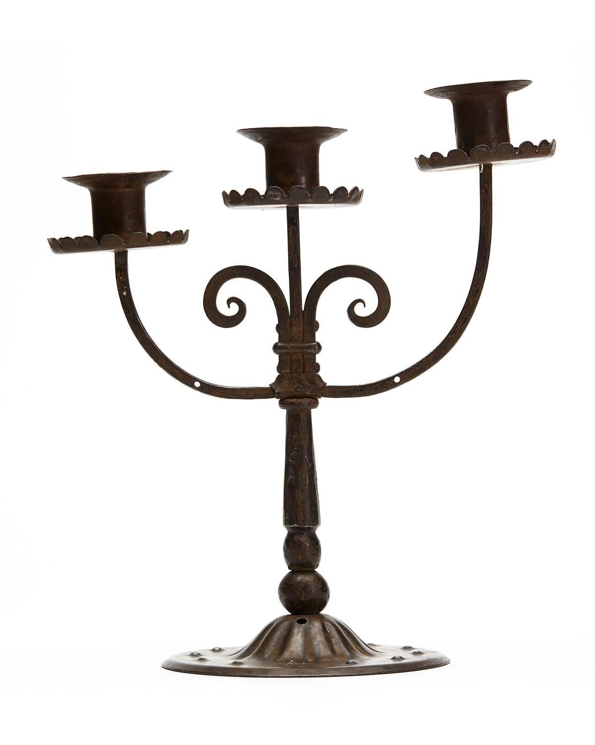 A stylish Austrian secessionist Industrial art patinated steel triple candlestick by Hugo bergere. The candlestick stands on a wide rounded foot with box steel arms with the three candleholders at graduated levels. The outer stems are drilled to