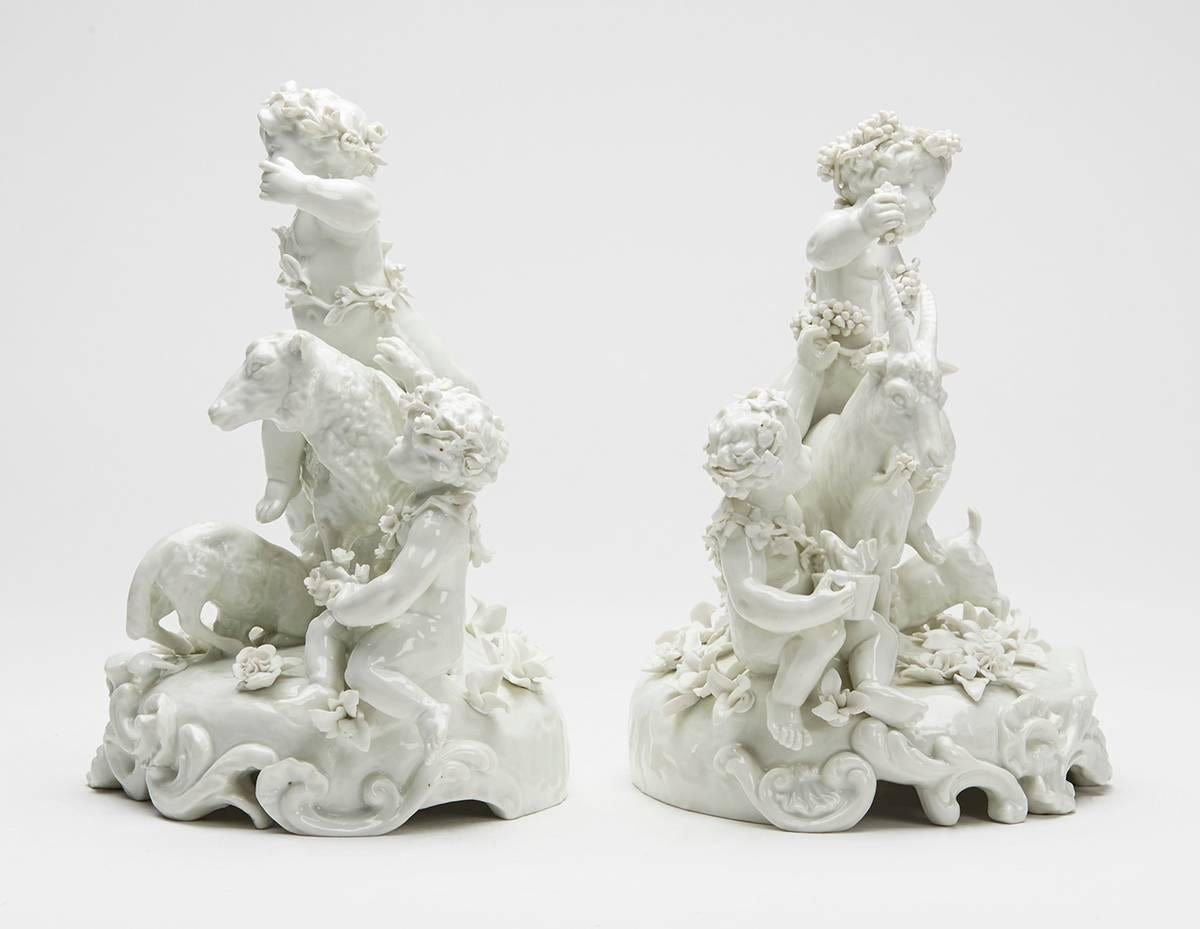 An exceptional pair of antique Austrian Vienna porcelain blanc de chine figure groups of putti with goats and sheep. The figure groups are mounted on a moulded rounded stand applied with floral designs, one with two young putti with a sheep with a