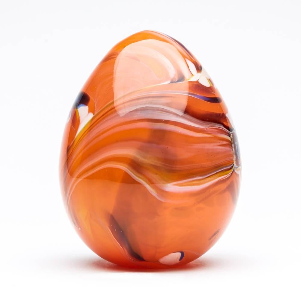 A fine and stylish Italian Murano hollow blown art glass egg-shaped sculpture, with large murrines and trailed colored glass through a bright orange coloured body. The sculpture has a flat polished base and is not marked.