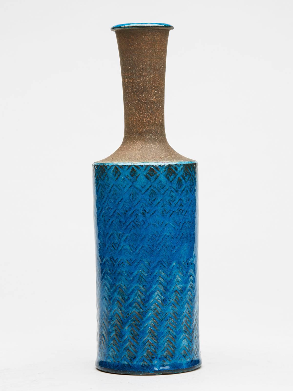 A very stylish Danish studio pottery bottle shaped vase by Nils Joakim Kahler (1906-1979) with a cylindrical shaped body with a moulded pattern decorated in turquoise blue glazes with a narrow unglazed neck and with glazed top rim and inside of