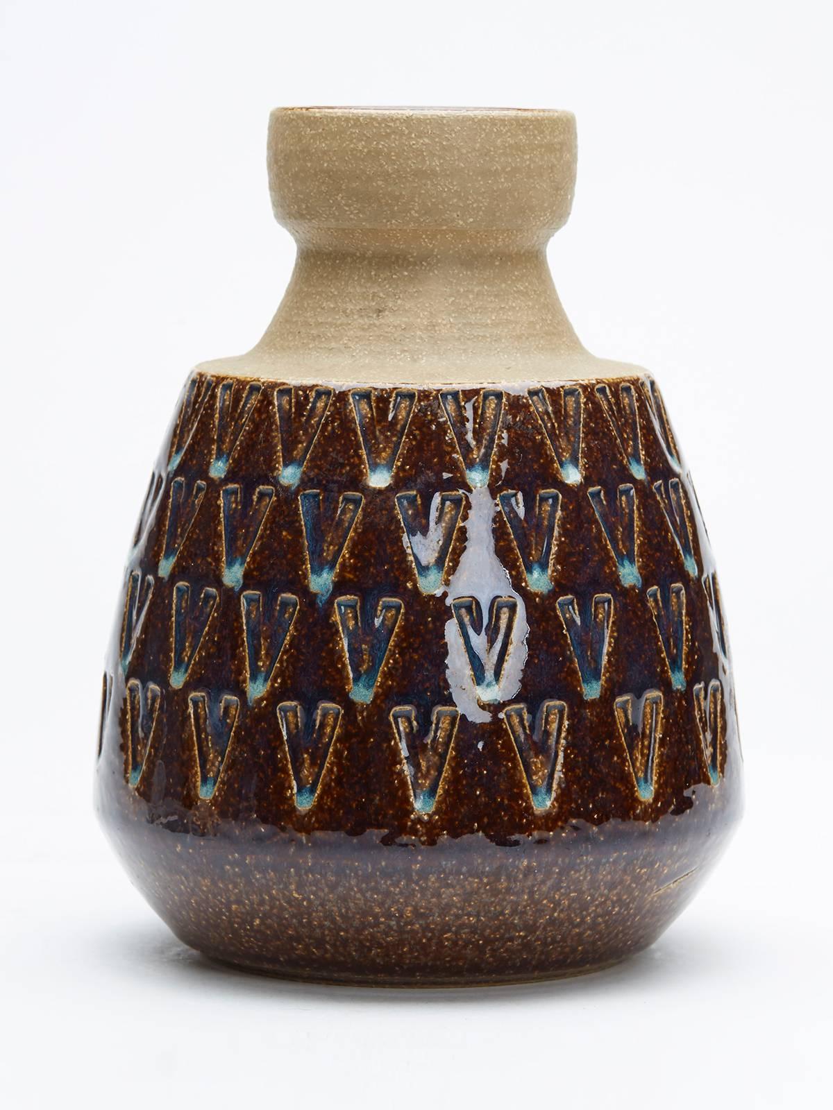 A stylish vintage Danish art pottery vase with an incised V-pattern design glazed in mottled brown and blue with the foot and should left unglazed. The vase is designed by Einar Johansen for Soholm Bornholm and is numbered 3190.