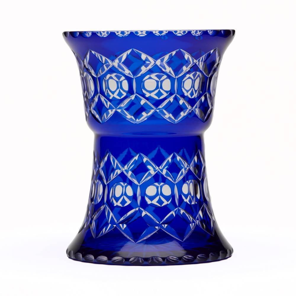 A stunning vintage Continental, possibly Bohemian, blue overlay cut-glass vase shaped as a bowl supported on a wide rounded base cut with diamond shapes and round windows with slice cut edges around the foot and top. The vase has a star cut base and
