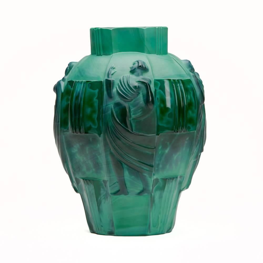 A stunning Art Deco Czechoslovakian malachite green glass vase moulded with figures designed by Artur Pleva for Curt Schlevogt. The vase combines polished and matted elements with four semi clad female dancing figures set between carved panels. The