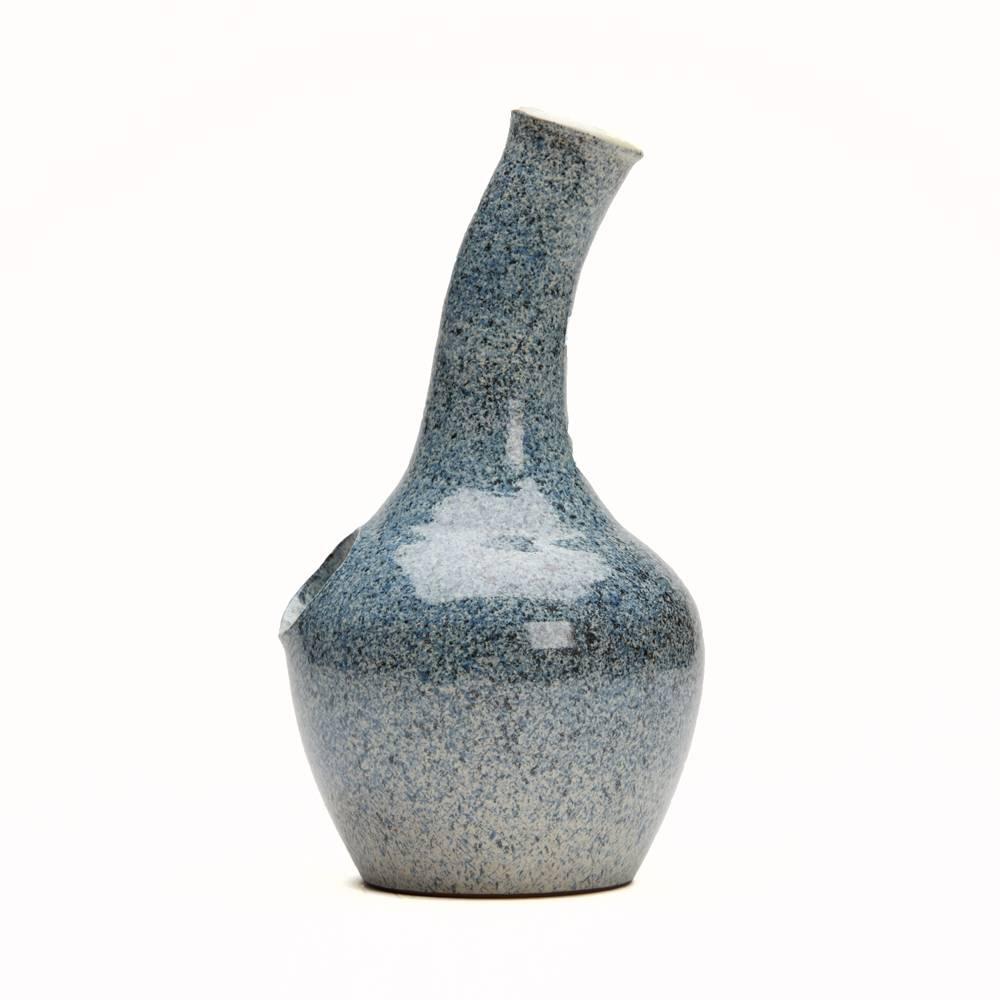 A stylish Studio Pottery bottle made at Loughton Pottery by Thomas Weir Howard. The stoneware bottle has a rounded bulbous shaped body a slightly angled neck and a hole in the body to accommodate a wooden handle allowing the contents to be poured.