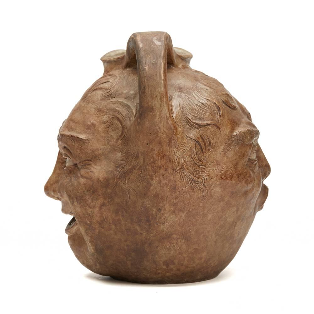 Ein seltener, extra großer Steinzeugkrug der Gebrüder Martin von Robert Wallace Martin aus dem Jahr 1897 mit einem grinsenden Gesicht, das die Zähne zeigt, und einem blasenden oder pfeifenden Gesicht auf der gegenüberliegenden Seite. Der Krug mit