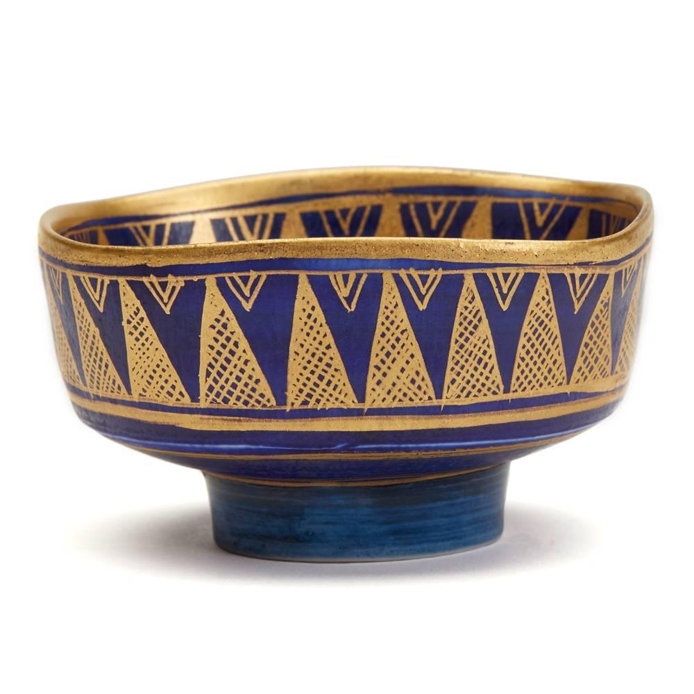 A very fine and stylish Studio Pottery bowl of open square form standing on a narrow rounded foot and finely decorated with a richly gilded geometrical pattern on a deep blue ground in Islamic style crystalline glazes. The porcelain bowl has an