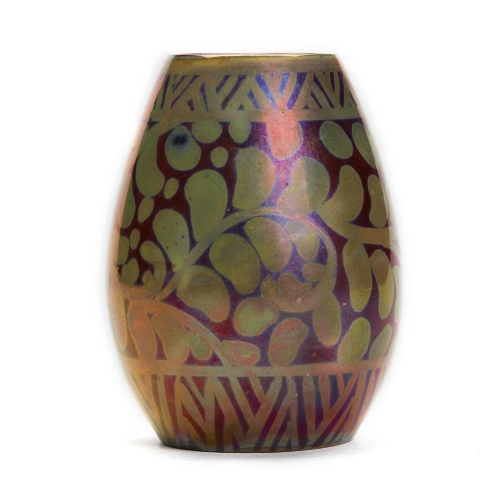 A stunning and rare Burmantofts Faience scrolling foliage vase by Joseph Walmsley, decorated with scrolling foliage in golden lustre on a ruby lustre ground with a lustrous gloss finish. The small bulbous shaped and lightly potted vase has impressed
