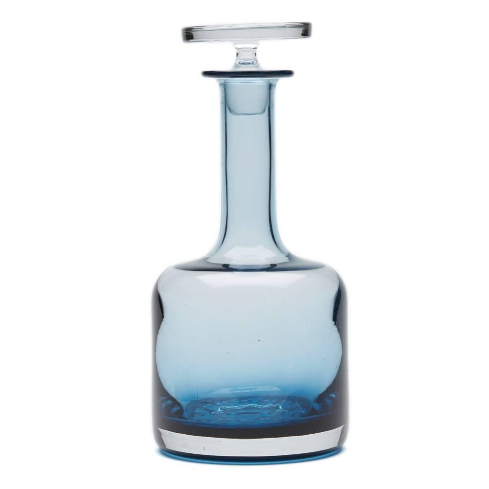 A stunning and scarce vintage Wedgwood blue glass whisky decanter and stopper designed by Ronald Stennett Willson in 1969. The decanter has a rounded cylindrical shaped body with an indented pattern to the base and has a narrow slender neck with