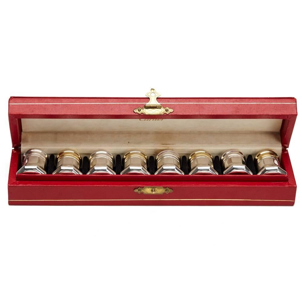 An unusual boxed set of four pairs silver cruets with screw down covers with gilded covers to the pepper cruets. The lightly made cruets each have Cartier Sterling marks to the base and are presented in a red fitted case marked Cartier in gold to