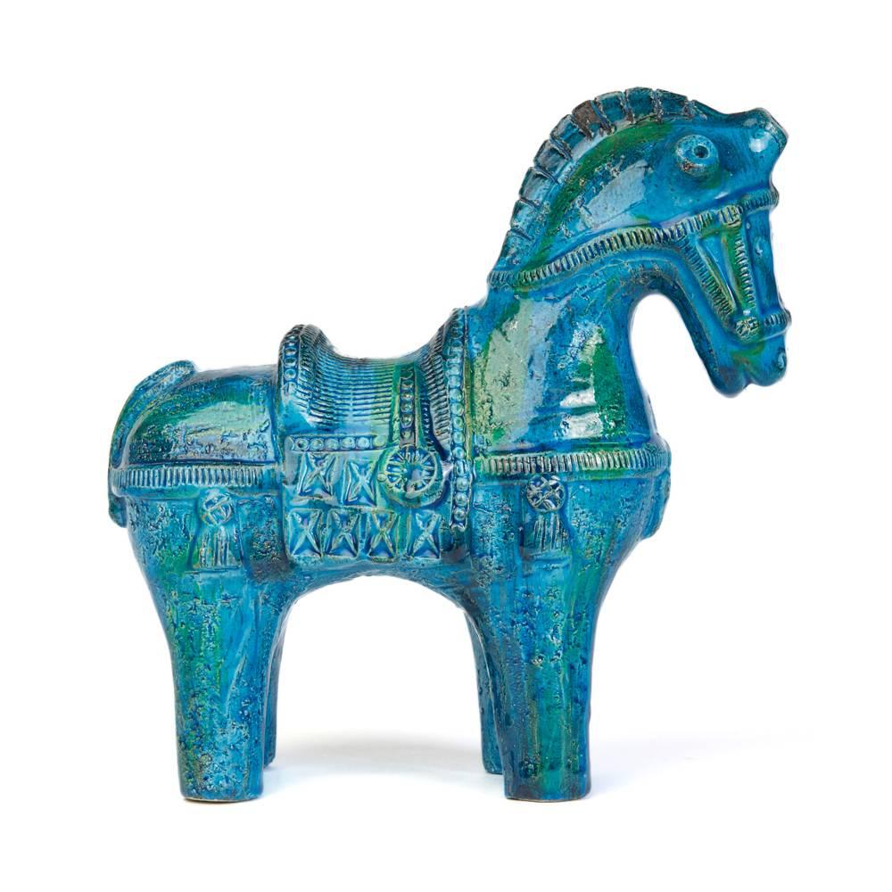 A stylish vintage iconic Italian Bitossi 'Rimini Blu' decorated ceramic horse designed by Aldo Londi. The standing horse with saddle and reigns with hand moulded designs is decorated in blue (turquoise), green and black glazes and is marked ITALY