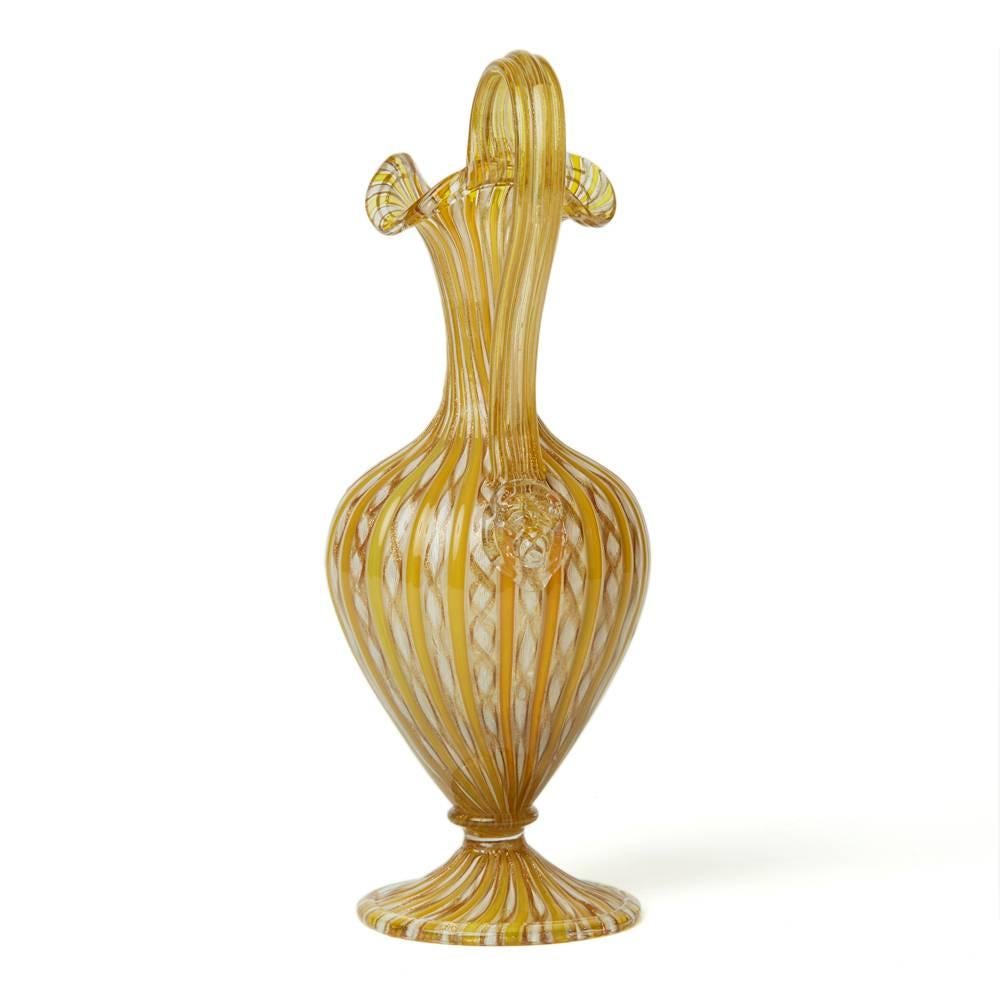 A stunning antique Italian Venetian zanfricio ribbon Roman revival art glass handled ewer attributed to Salviati. This finely made hand blown glass ewer is of elegant shape standing a rounded pedestal foot with folded rim with knop stem and rounded