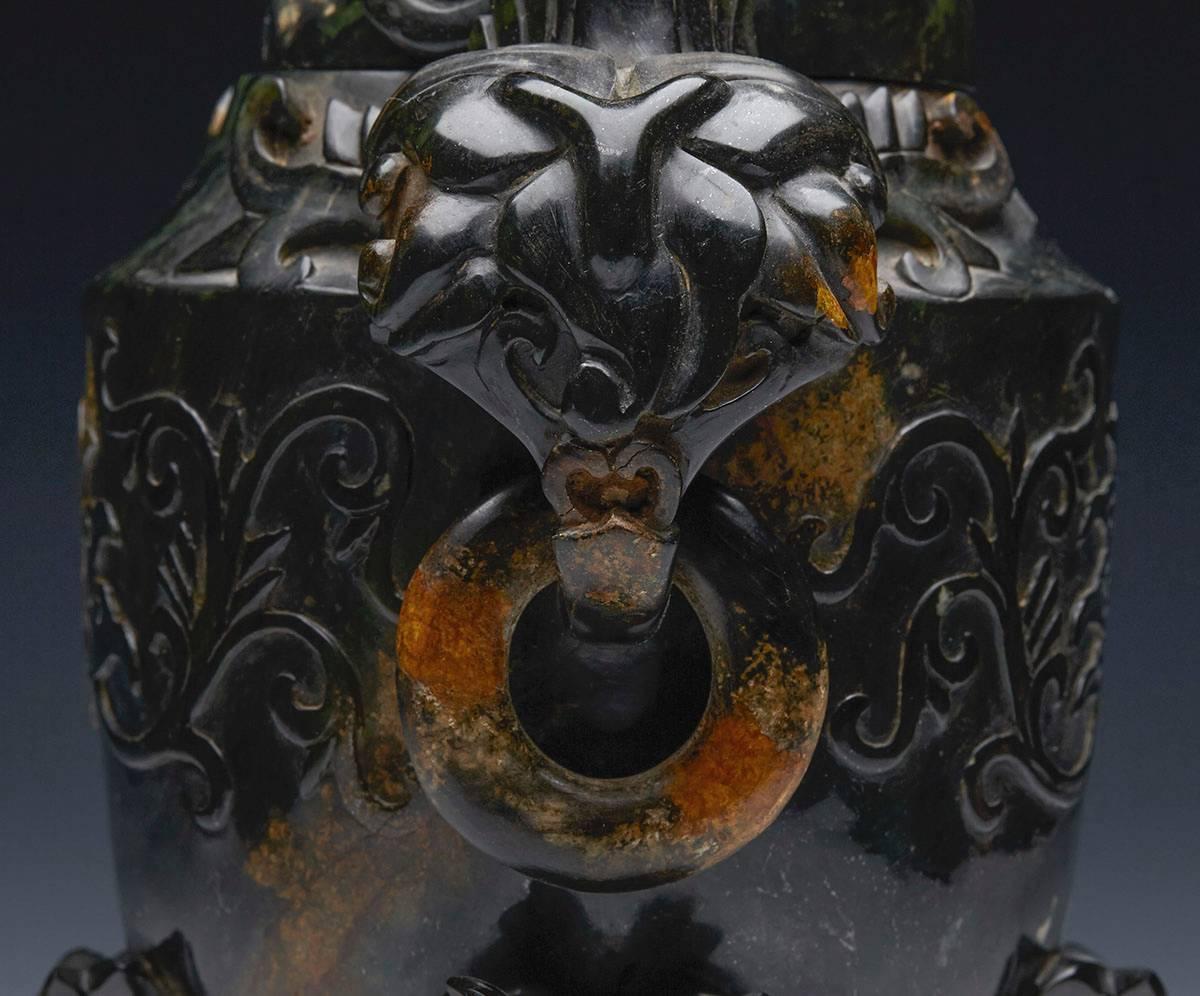 An unusual Chinese carved nephrite jade lidded urn or jar supported on four carved leaf feet, each with free hanging rings. The urn shaped body is carved in relief with trailing floral designs with raised leaf handles carved to either side again