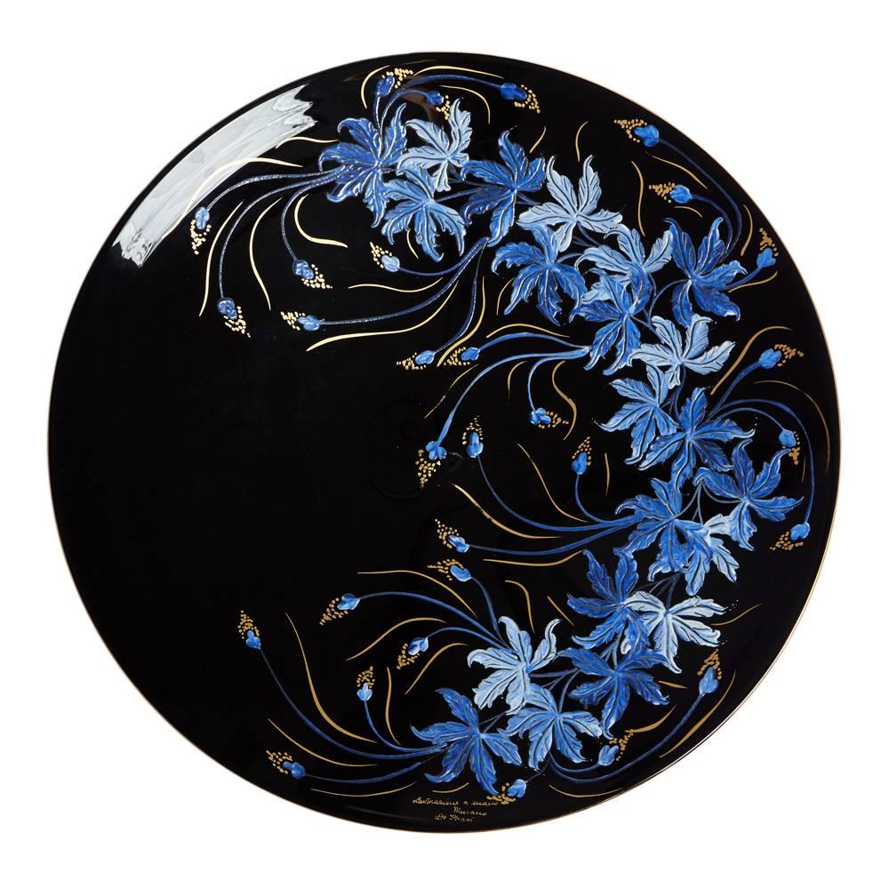 A large and very impressive vintage Italian Murano art glass charger enameled with trailing floral designs by Lavorazione a Mano. The large black glass shallow rounded bowl shaped charger has a gilded rim and is finely hand decorated with blue