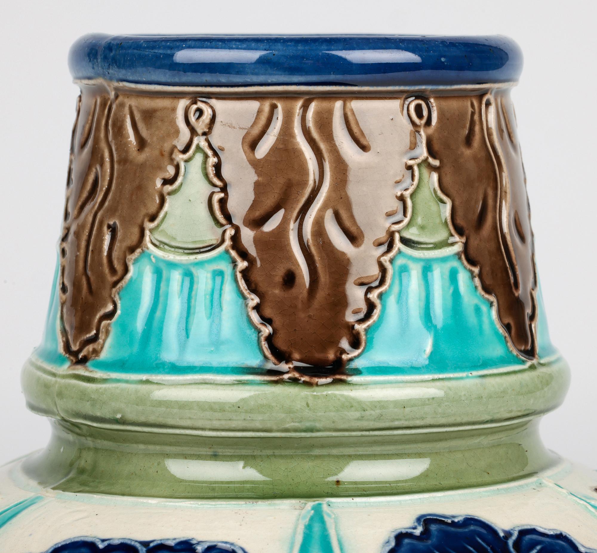 Rare et exceptionnel vase Parti Ware en faïence de Burmantofts, décoré de panneaux floraux bordés de tubes et datant d'environ 1895. Ce superbe vase en terre cuite légèrement empoté repose sur un pied étroit et arrondi avec une base légèrement en