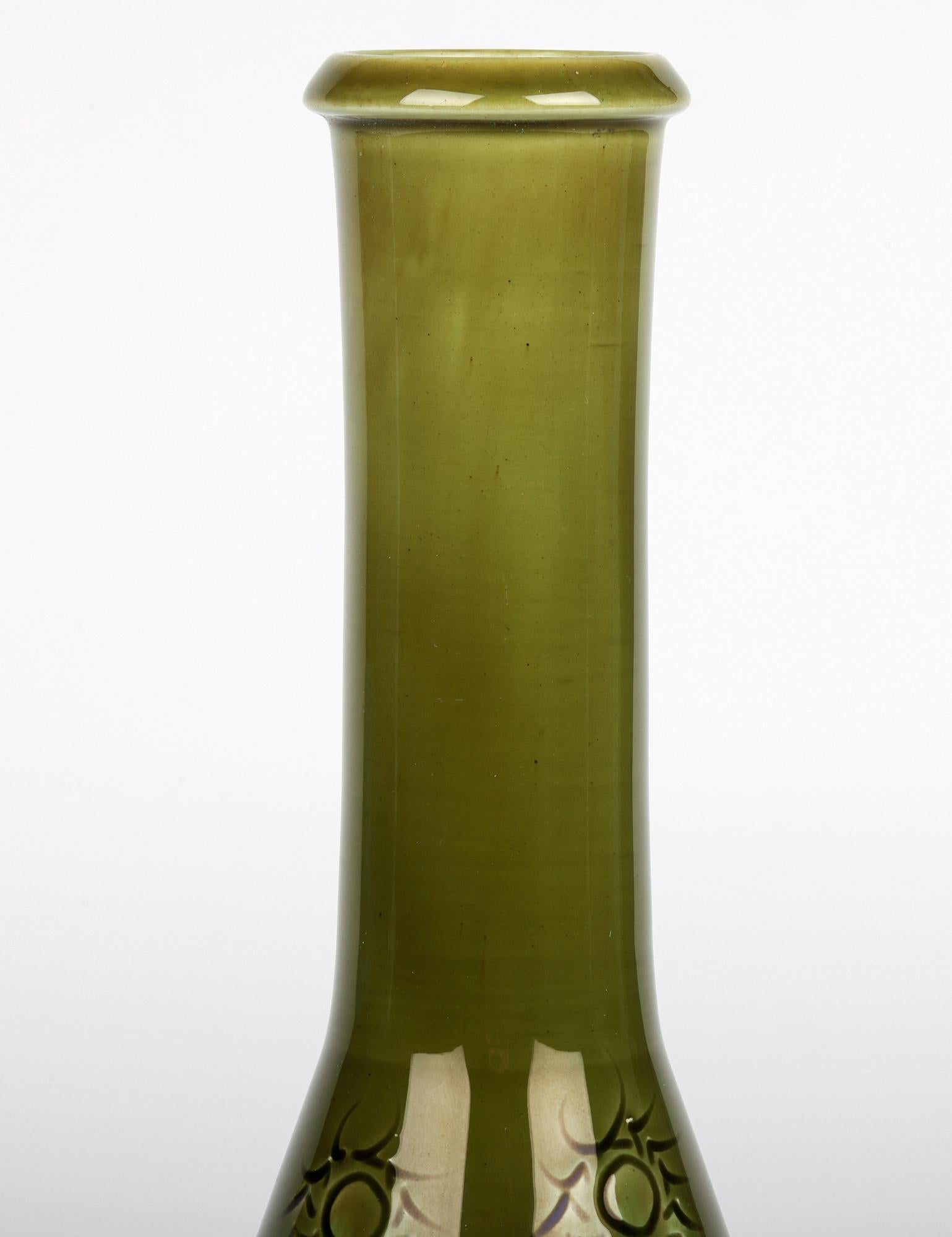 A rare and stylish Burmantofts Faience art pottery flask shaped vase with sun burst patterning and decorated in green streaked glazes and dating from around 1890. This stunning lightly potted earthenware vase is of tall, elegant shape standing on a