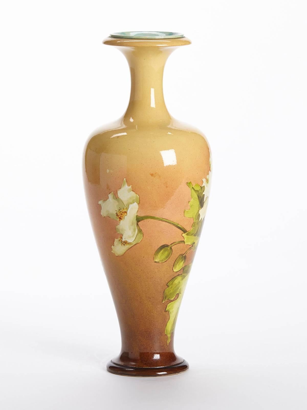Originating from an extensive private art pottery collection we offer this elegantly shaped antique Doulton Lambeth Faience vase hand decorated with floral designs and dating from, circa 1880. Indistinctly signed this tall stoneware vase stands on a