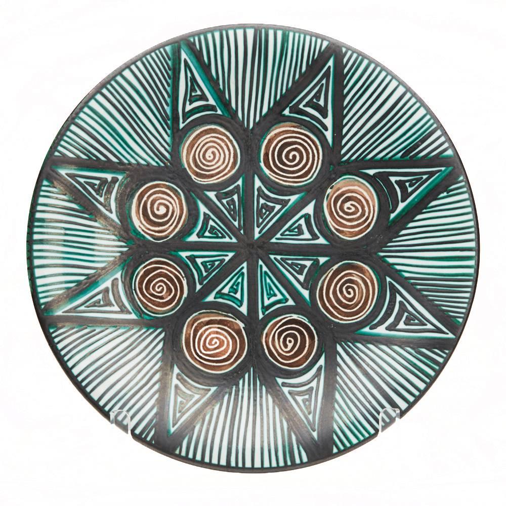 A rare and important stunning French art pottery plate or charger by Robert Picault and made in Vallauris in the South of France. Working closely to Picasso each piece is hand decorated with green, brown and incised patterned designs. Every item of