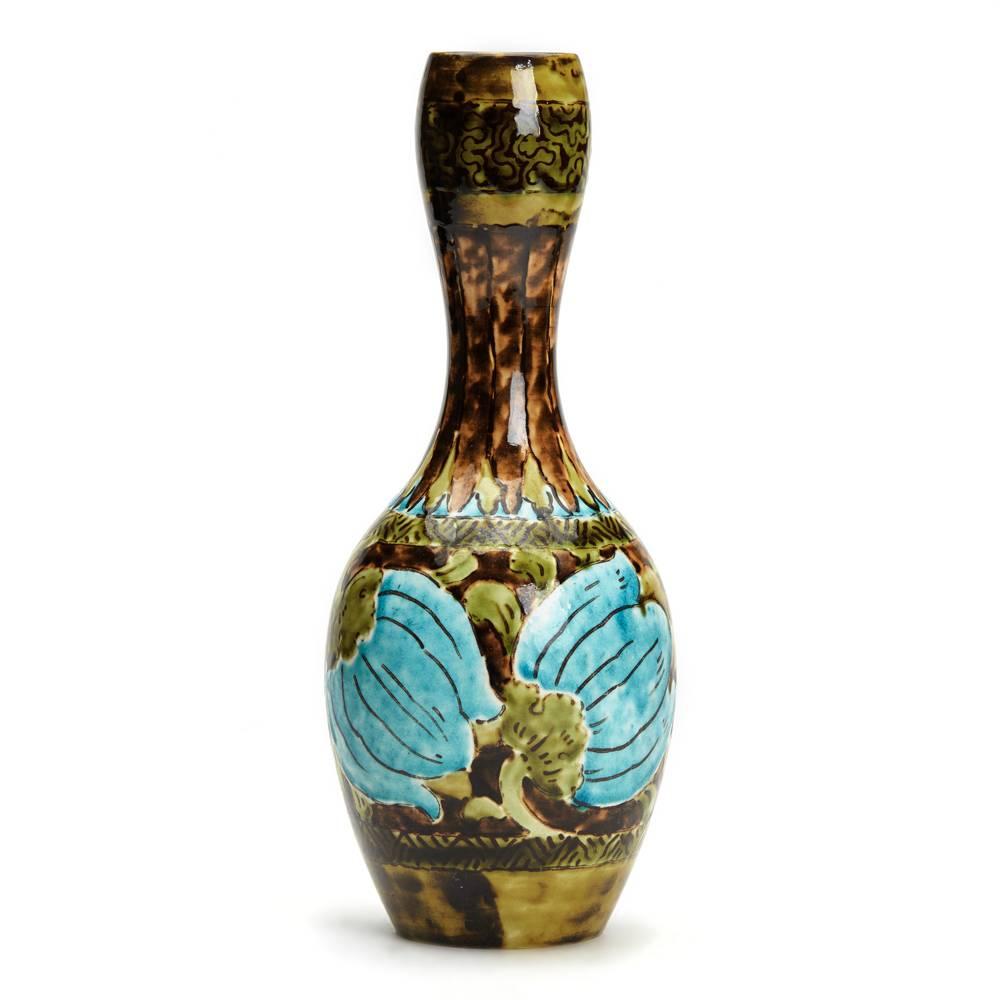 An unusual Burmantofts Faience Barbotine bottle vase painted with budding flowers in shades of green, brown and turquoise blue with a waisted neck and wider cup-shaped top. The vase is marked model no. 1529 and has impressed makers marks to the
