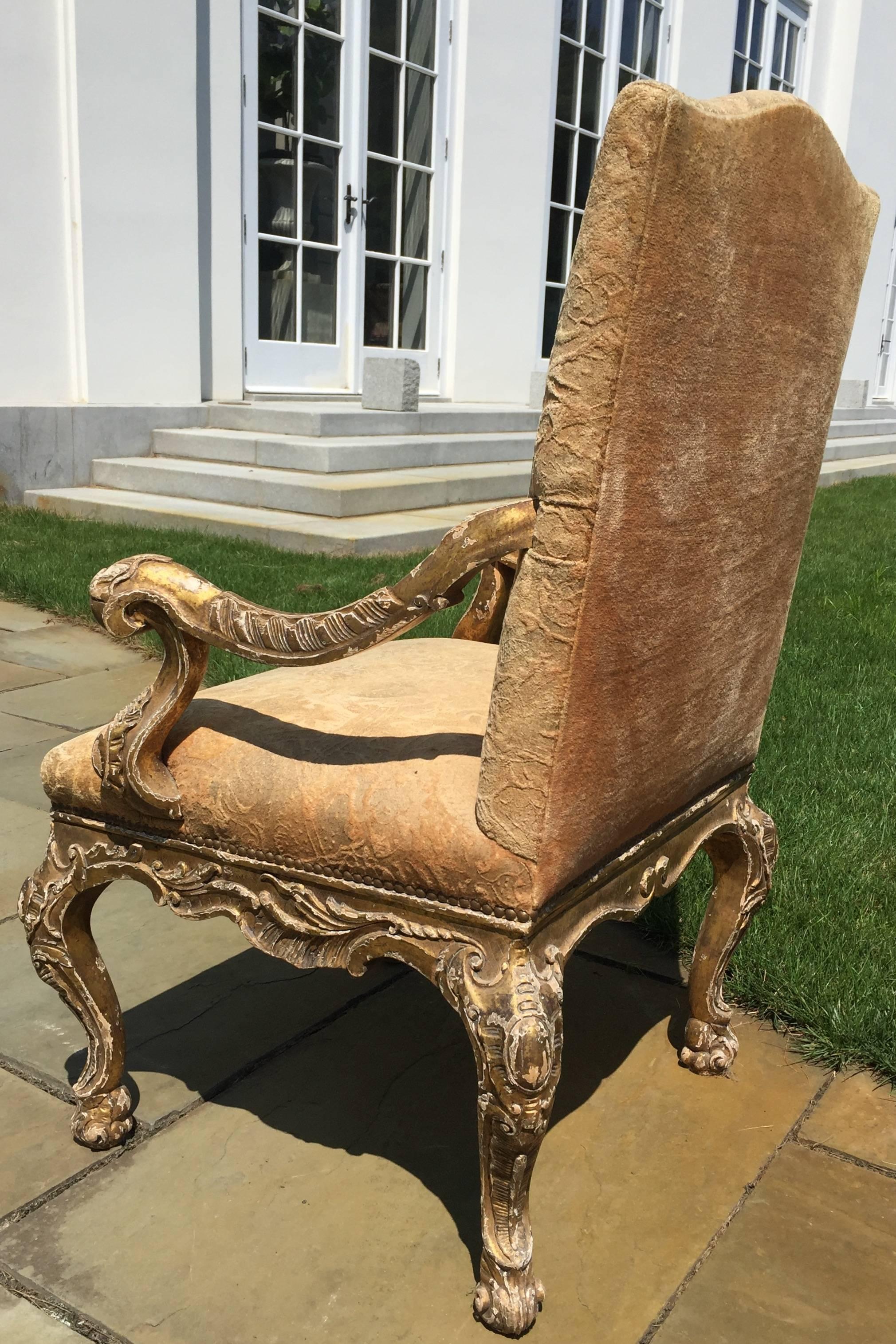 This beautifully hand carved Arm Chair looks like it dates from the Baroque Period, because the gold has distressing throughout that gives it the appearance of hundreds of years of age. It is constructed extremely well out of hardwood.
