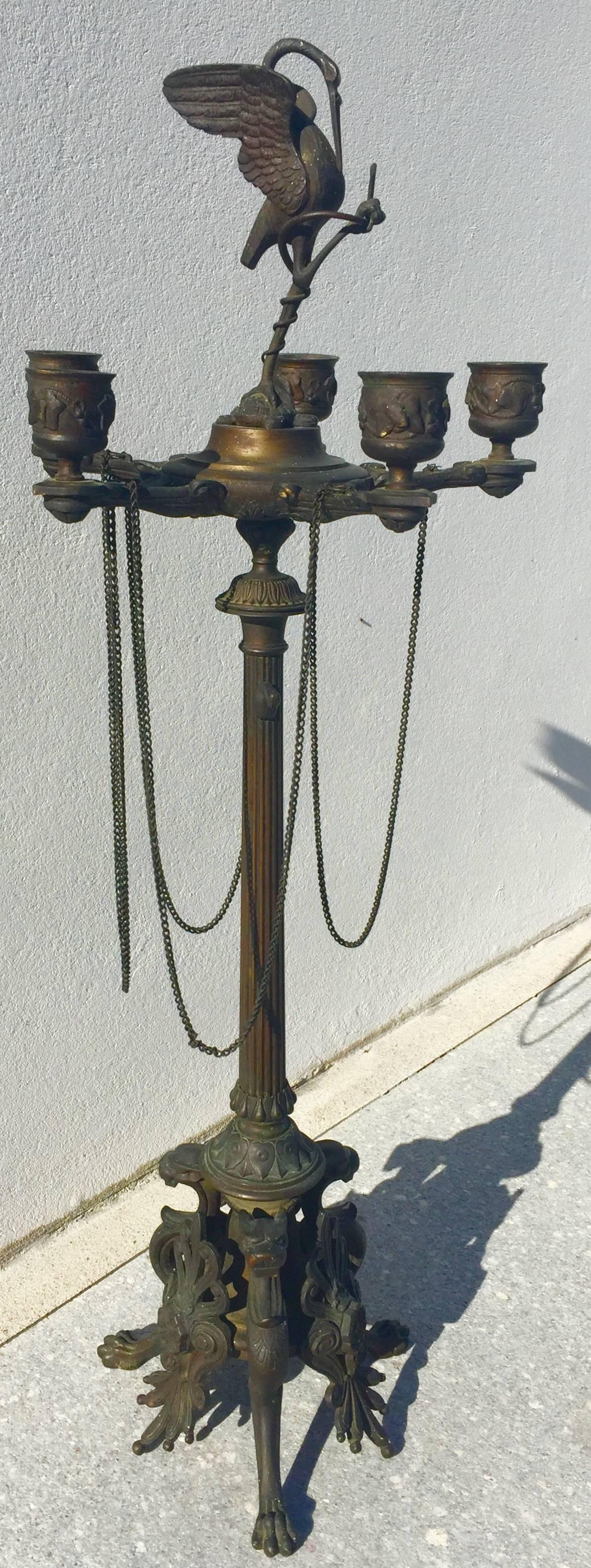 Tourists brought these home after visiting Italy during the grand tour period. They are cast of solid bronze in France.
Rising from the lion-footed base is a column holding a five-arm oil lamp with delicate chains hanging from it. The column has a