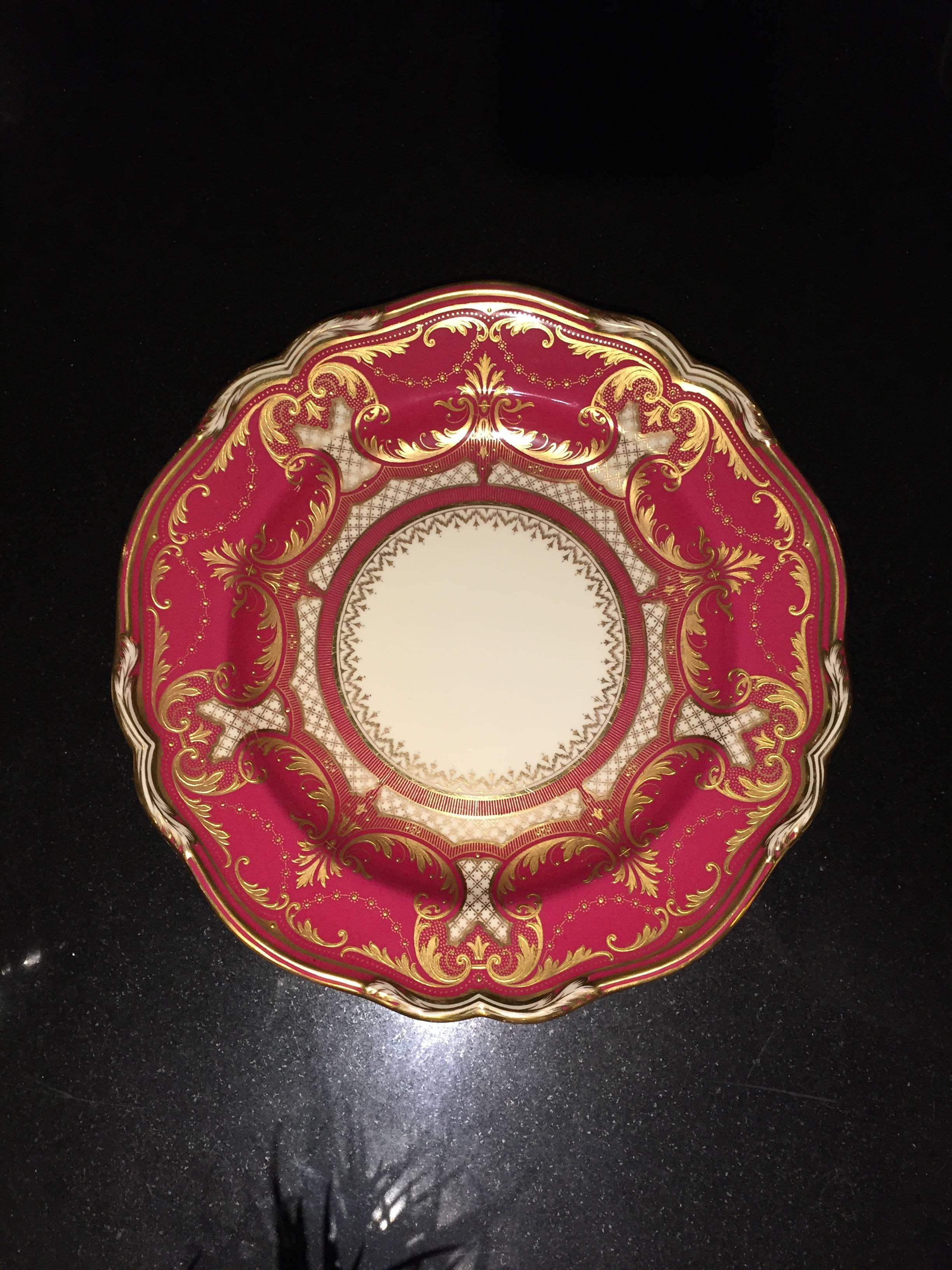This set of ten large dinner was manufactured by Spode Copeland and retailed by Tiffany & Co. NY. The magnificently rich magenta enameled scalloped edge border is decorated in foliate designs and pearl swags in 24-carat gold relief. They are in