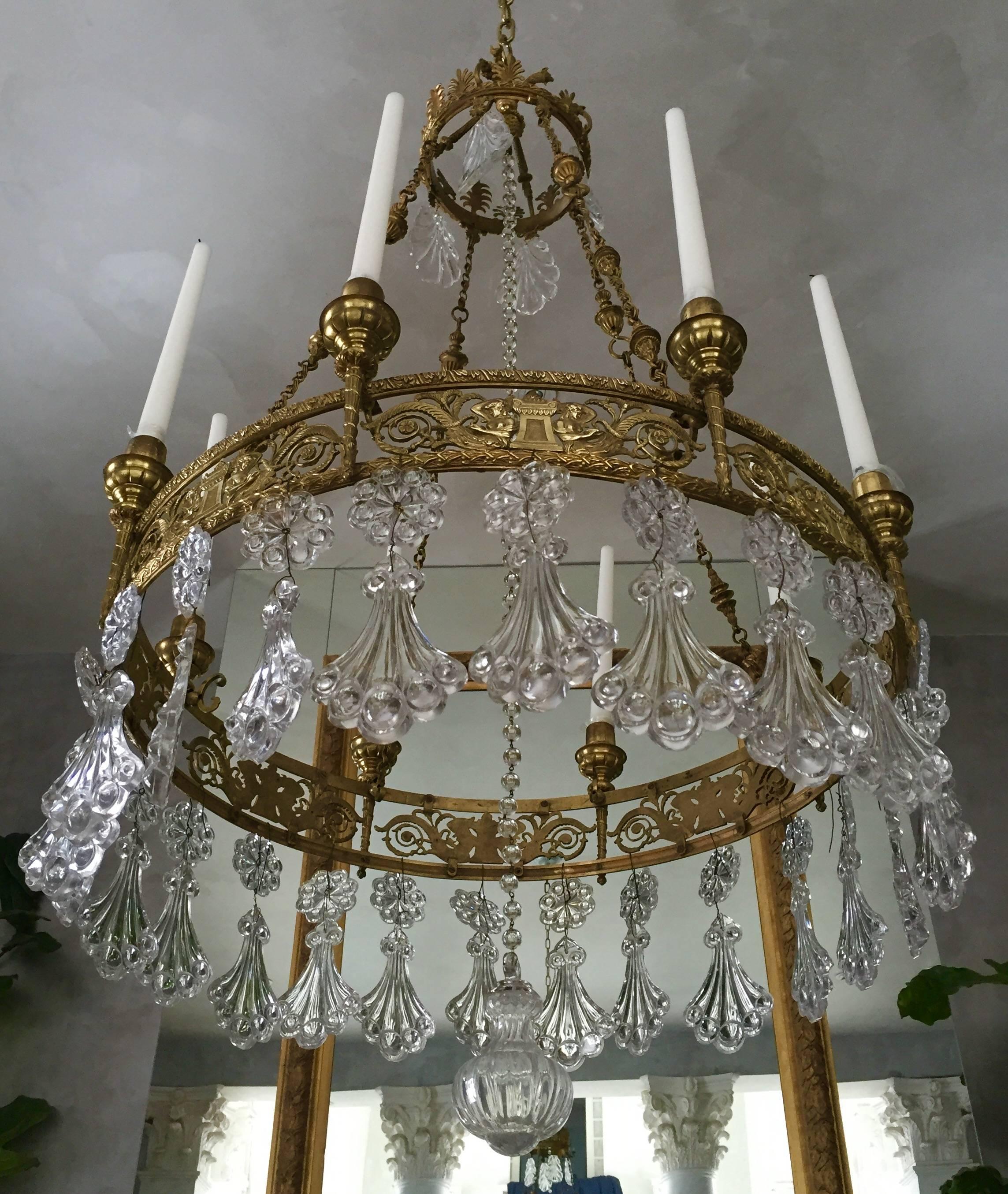 Elegant French Neoclassical style bronze eight-light chandelier, surrounded by peacock crystal prisms.
Ca 1890