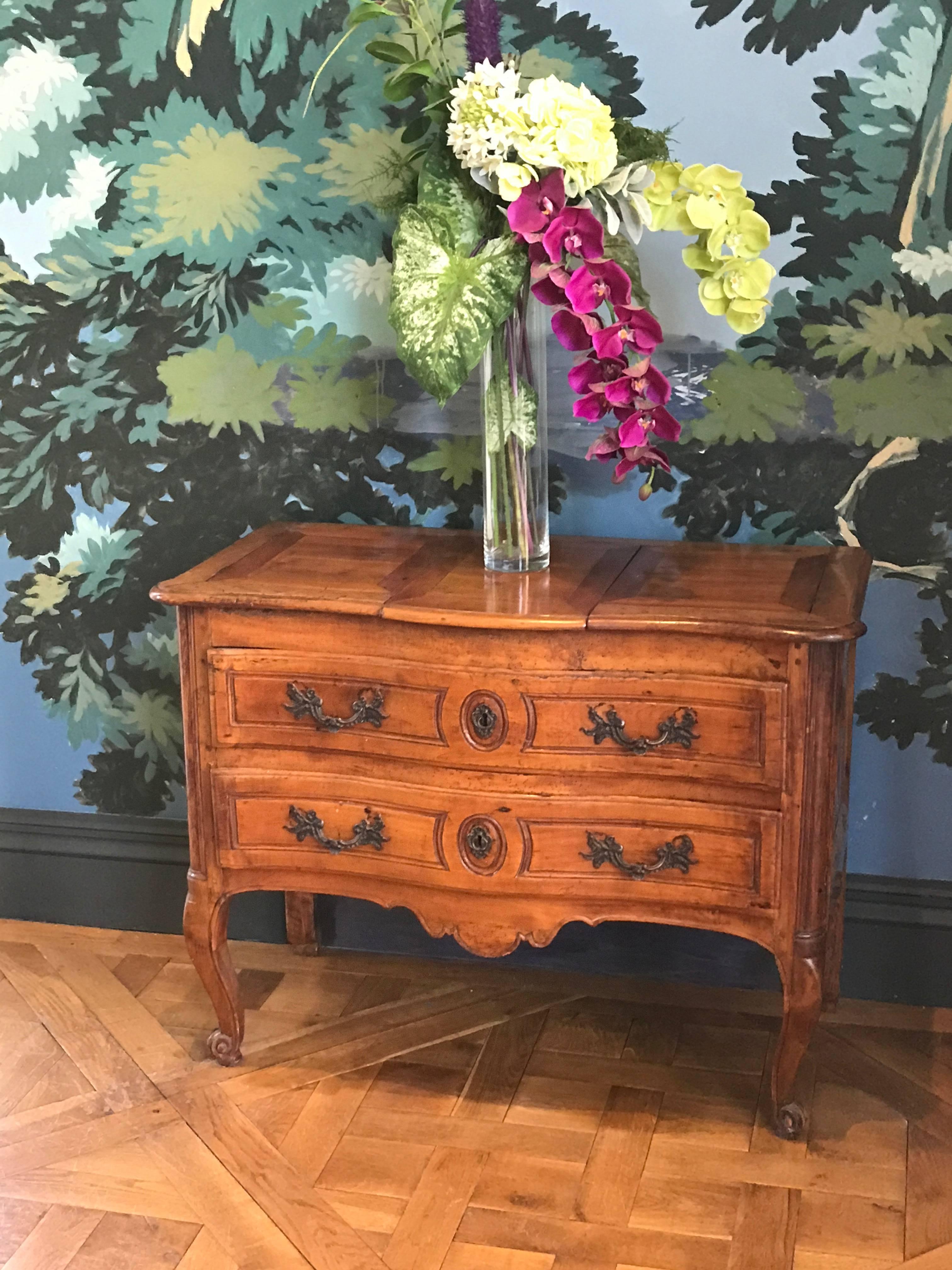 This Louis XV Period Cherry Wood Commode was hand made ca 1765.
Typically these French Provincial Commodes were made of Walnut, but in rare cases like this one they are made of much more rare Cherrywood. 
The graceful cabriole legs are hand