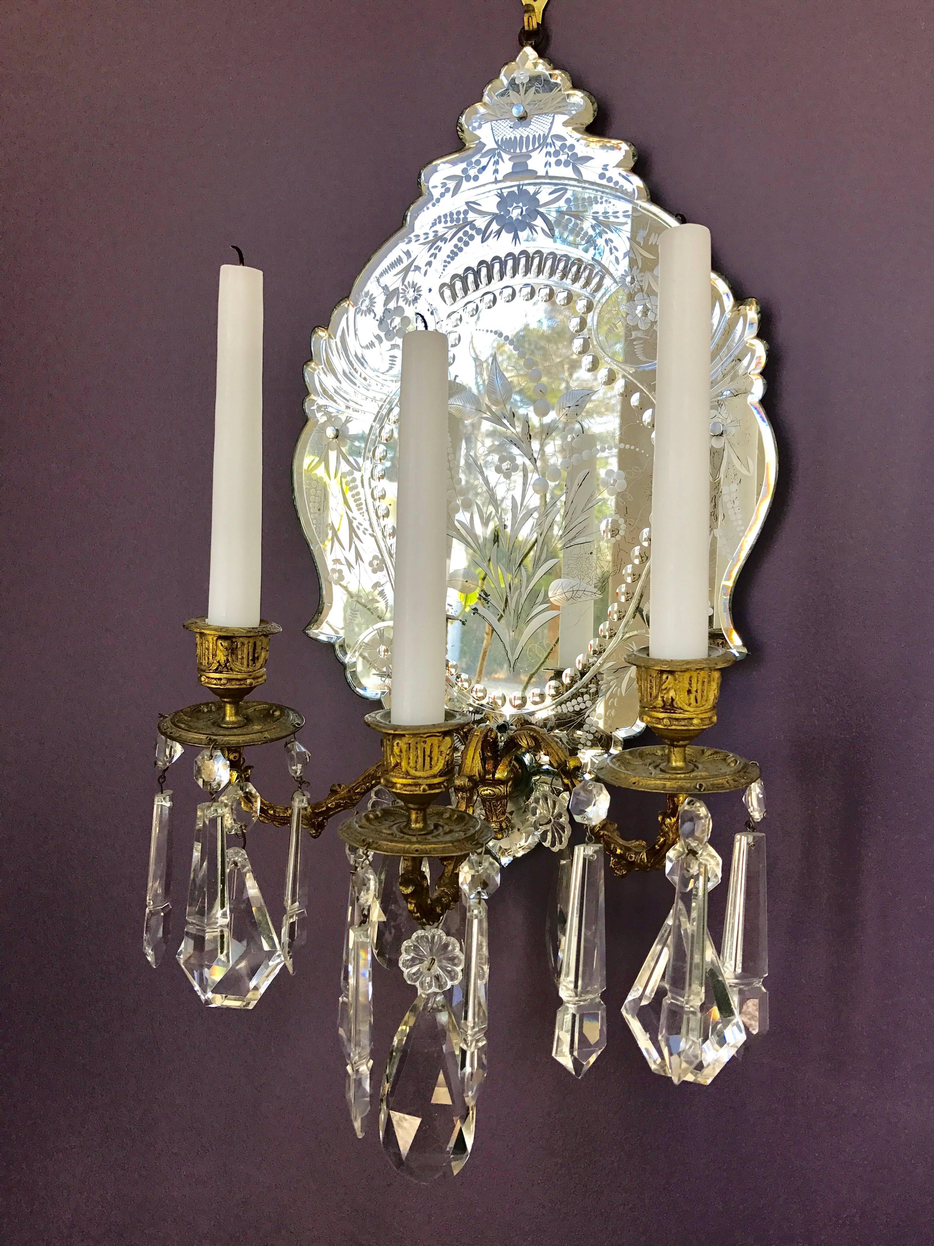 High quality Venetian Mirror three-arm wall sconce with an elaborately etched thick crystal mirror backplate. The 18th century style gilt bronze arms are decorated with lead crystal prisms. 
Measures: 23