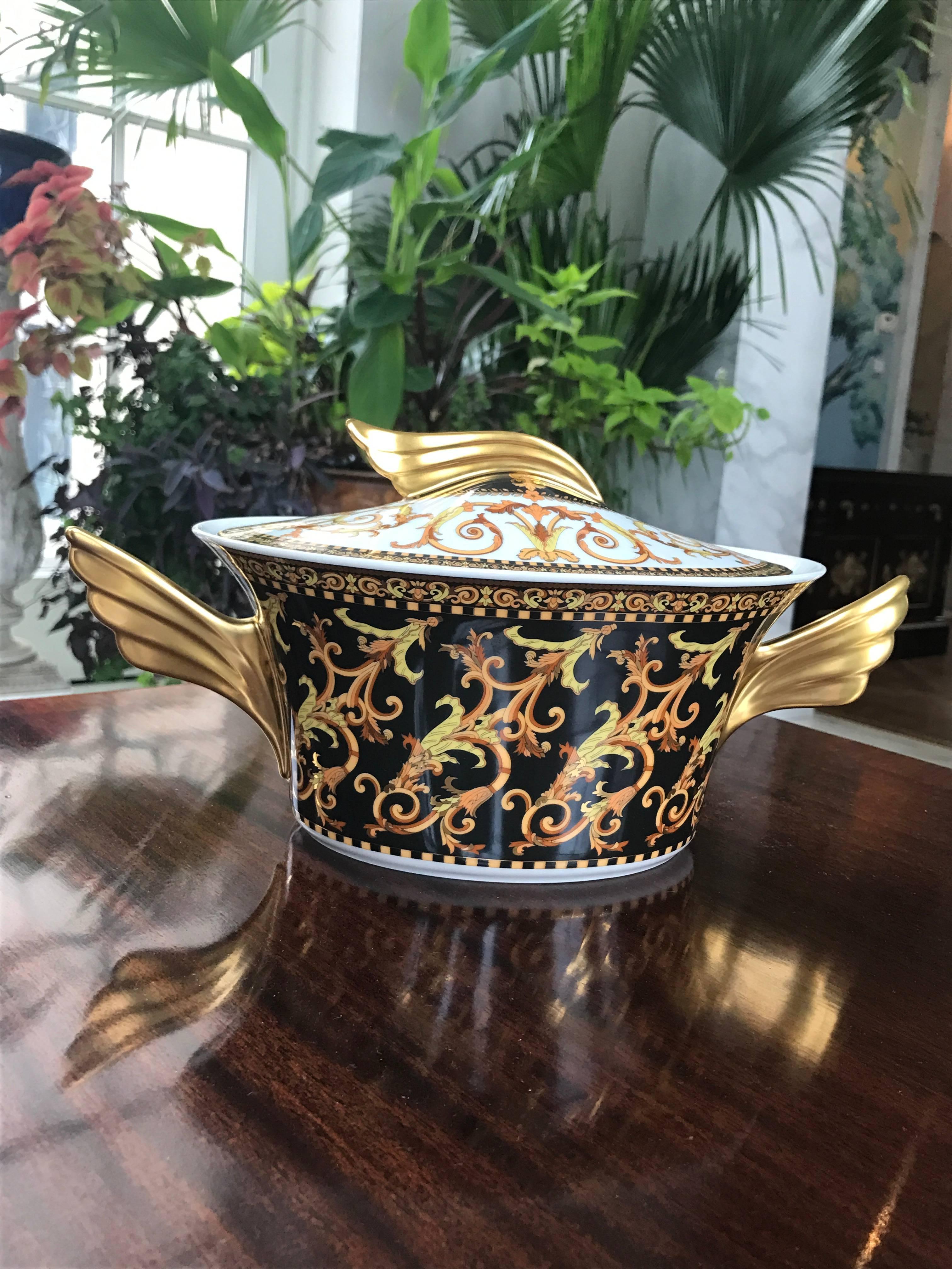 Classic Versace Tureen by Rosenthal with foliate pattern throughout in orange and yellow tones and 24-karat Gold accents on a black background. Signed underneath as shown in image #3. 