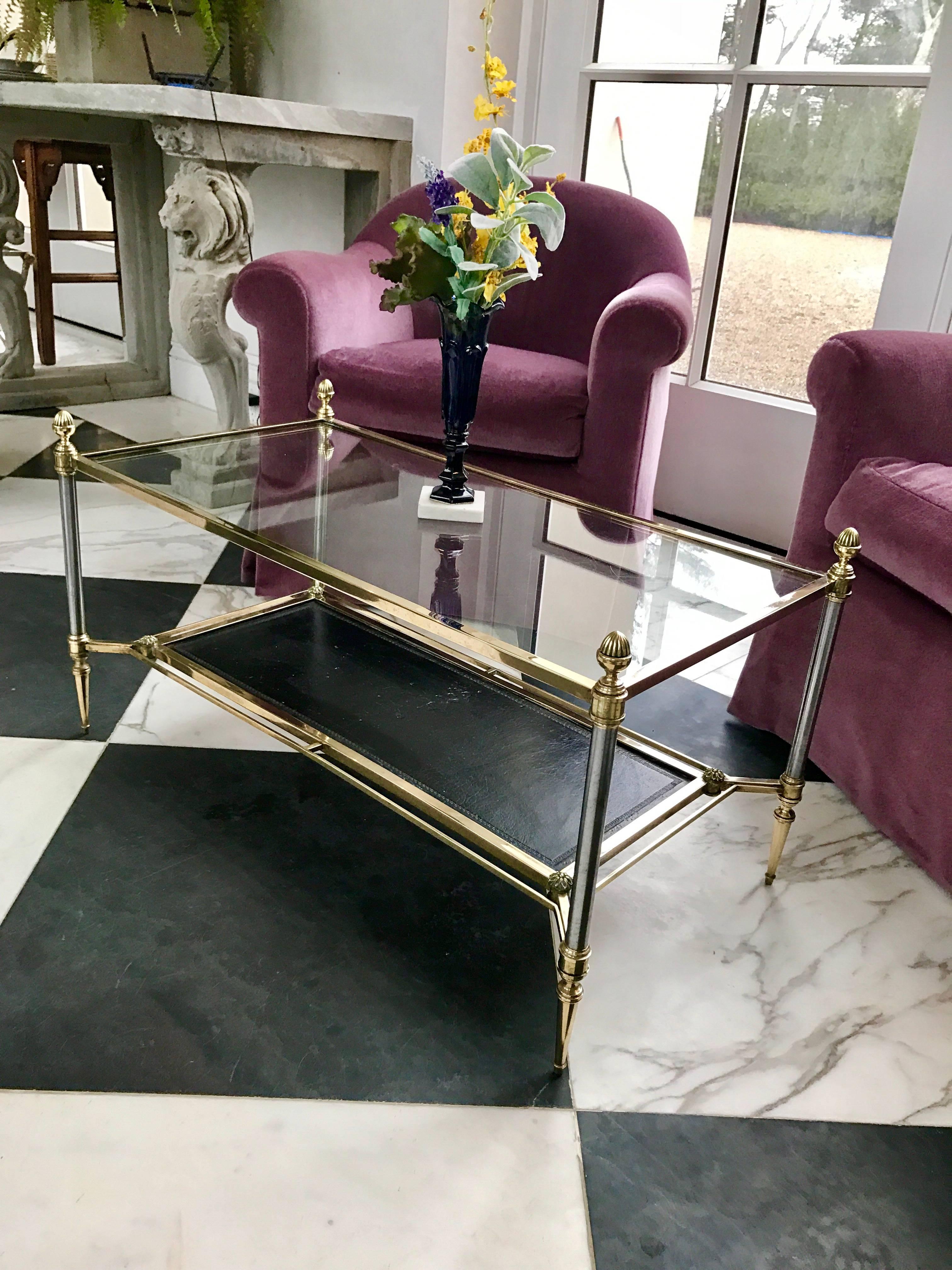 This stunning Pompeian style coffee table is made of solid elements throughout. Maison Jansen at it's finest! 
The original top is crystal glass, the shelf below has the original black leather and is tooled with a Meander Pattern on the