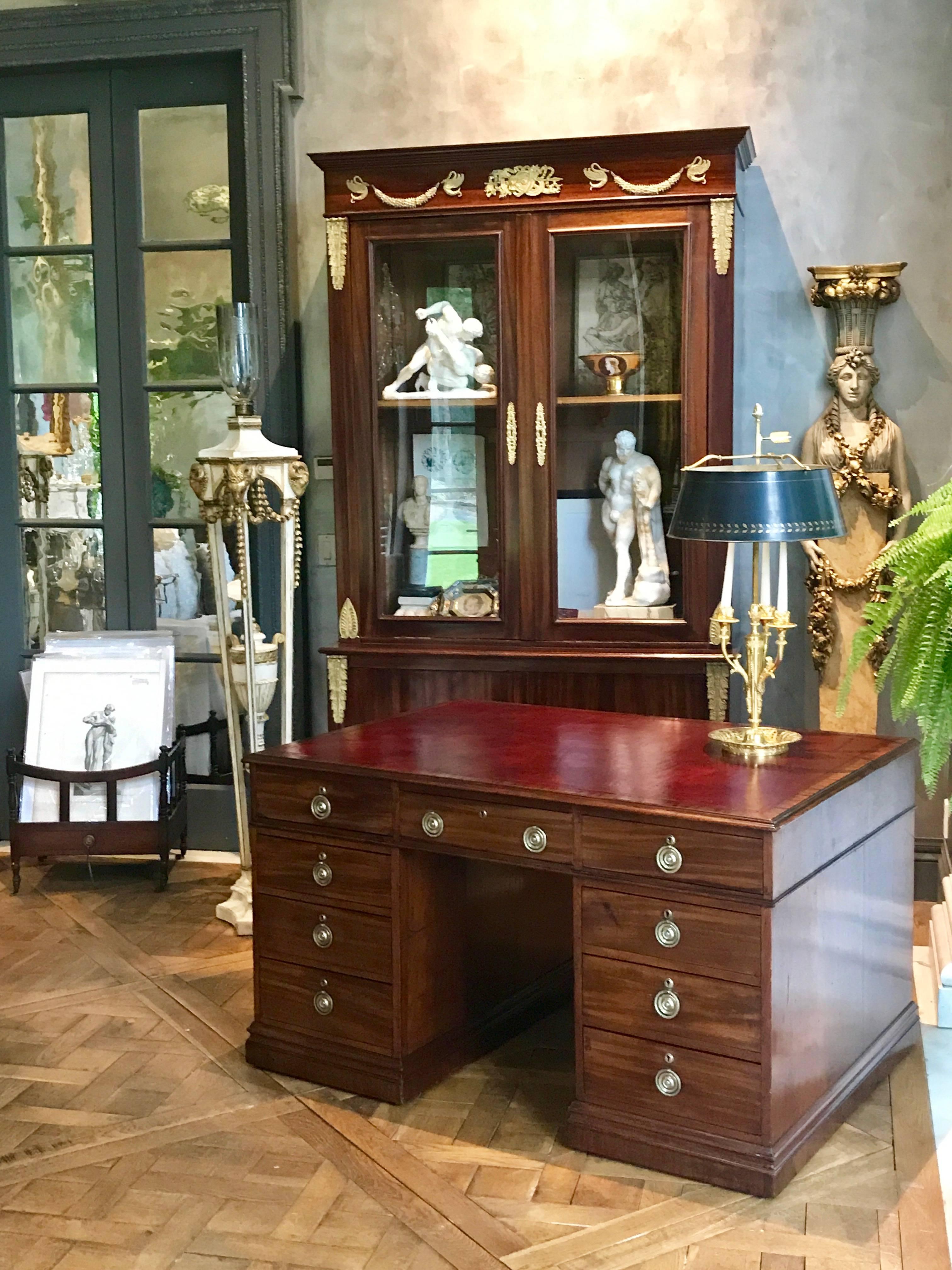 This beautiful George III period mahogany pedestal partners desk has an embossed deep red leather top.
There are 18 drawers in total. 
Made in England, circa 1830.