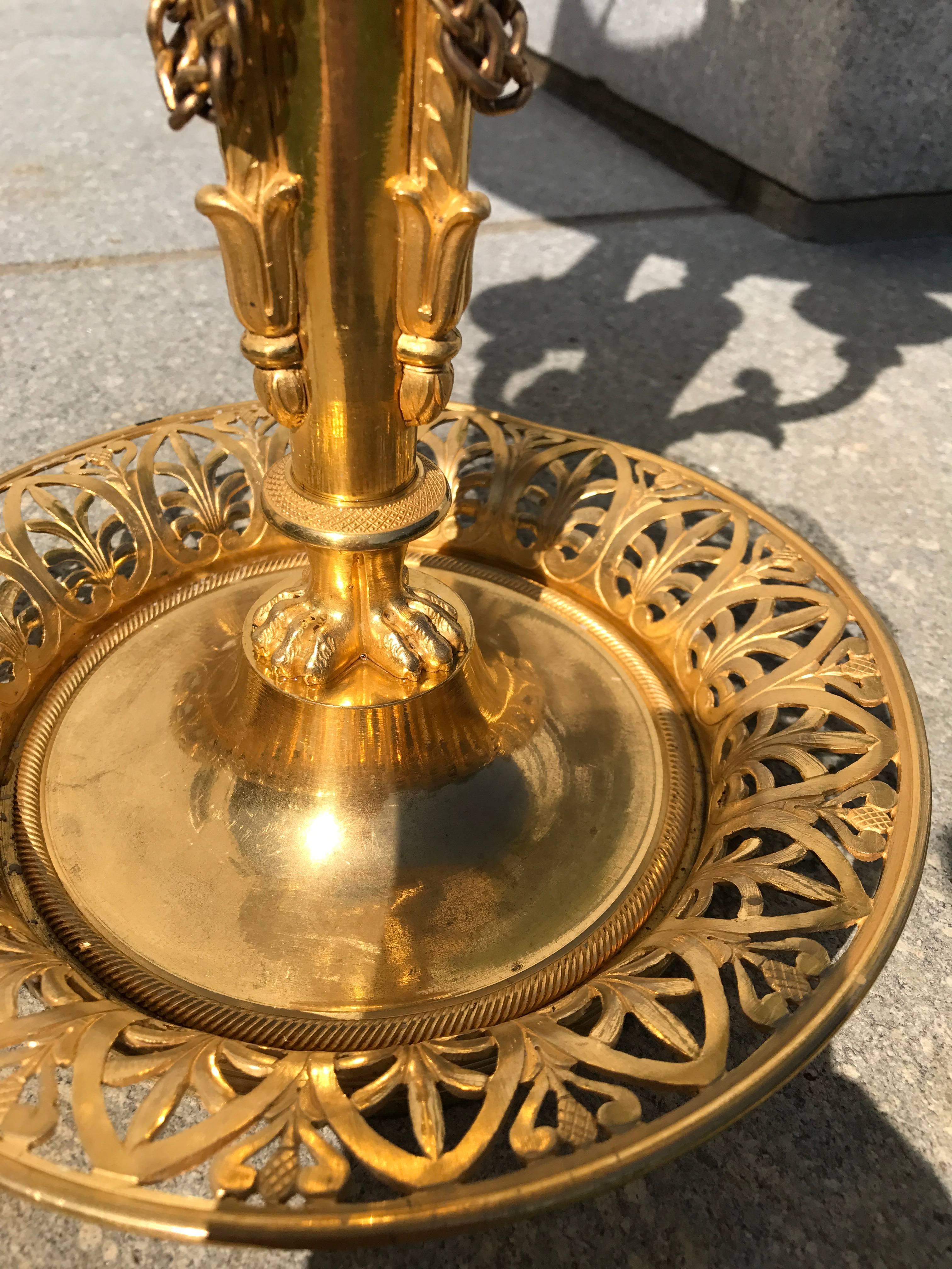 This fine French Bouillotte lamp has the highest quality ormolu and an original tôle shade held by swans.
The base, which would hold the Bouillotte game pieces is cutout in Athenians and is finely chased.
Three arms rise out of the central column,