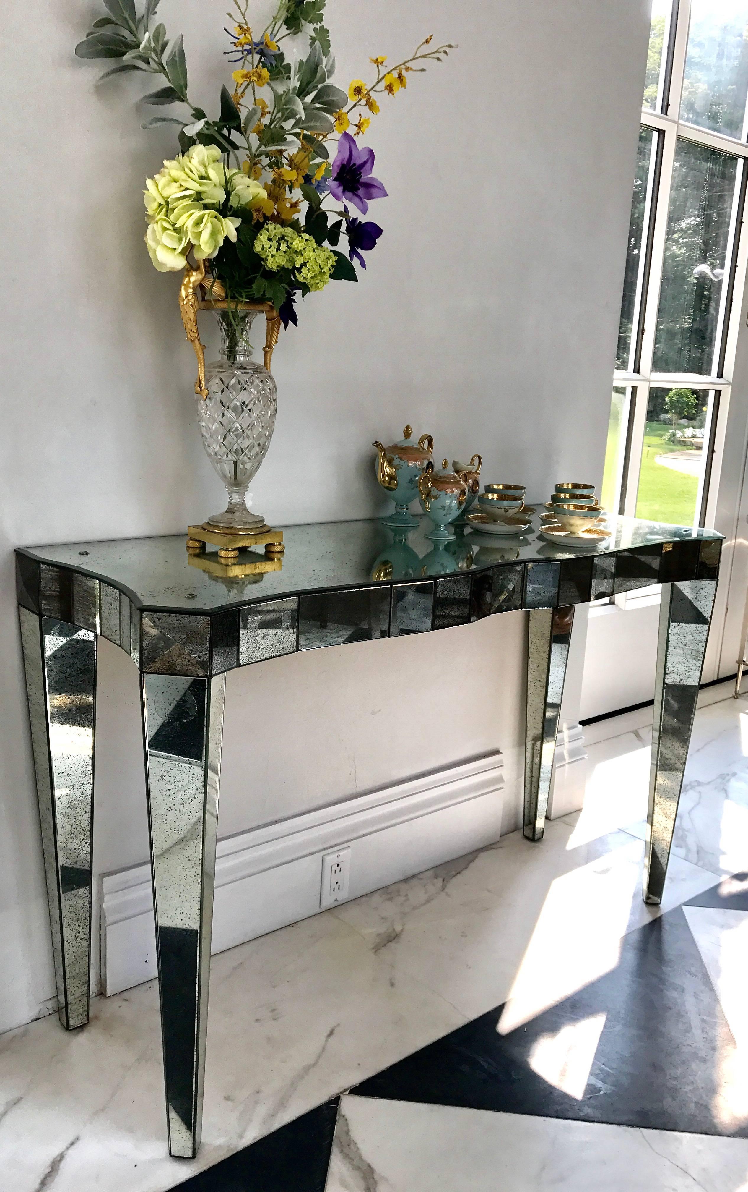 This elegant mirrored console table is attributed to Mirror Fair, New York, because it bared a paper label that unfortunately came unglued and disappeared.
Great effort was put into quality construction; hand selected antiqued mirror and bevelling
