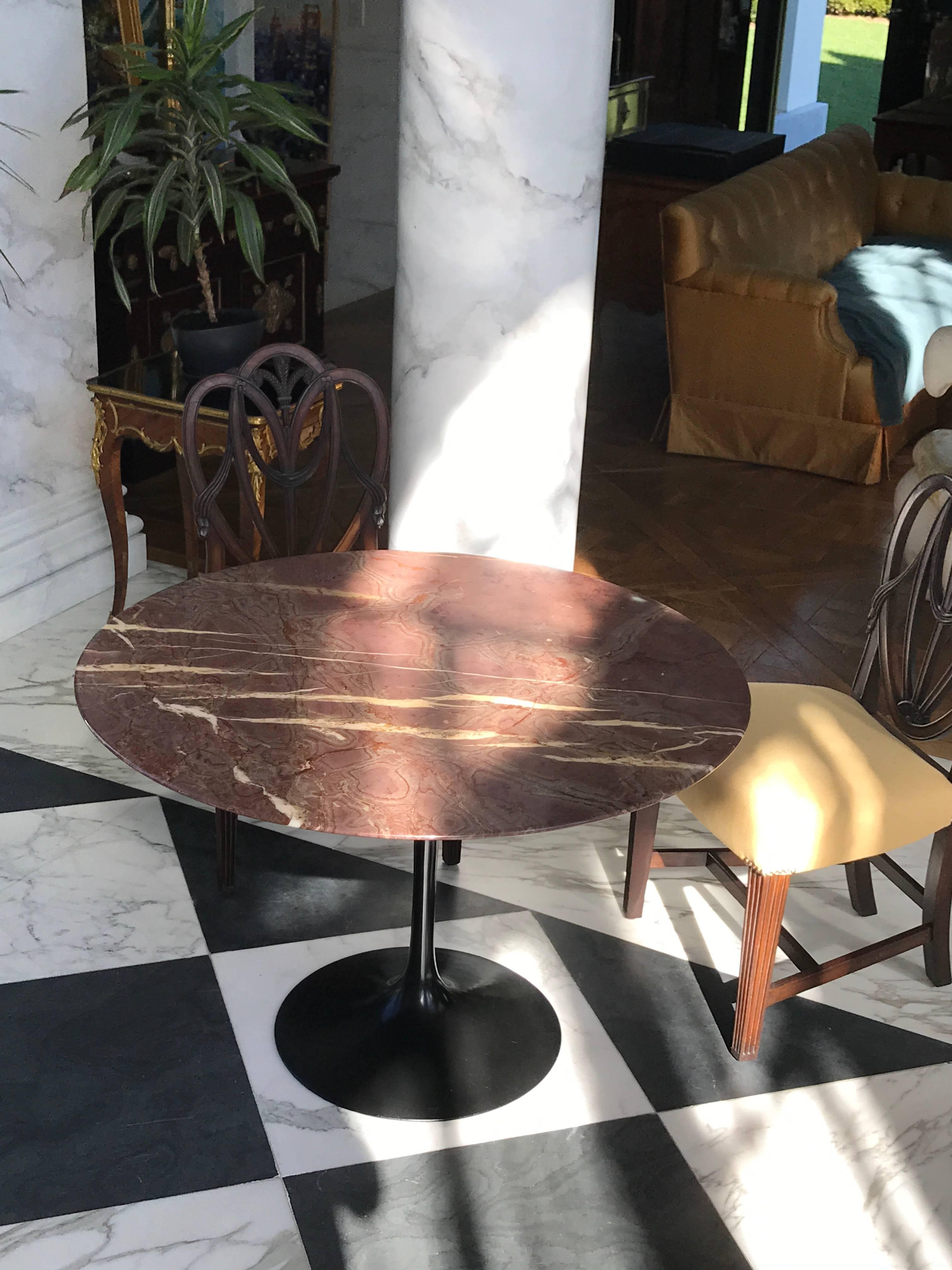 A wonderful Eero Saarinen marble-top dining table with tulip shaped black base. 
The Classic Mid Century Modern design of this table is to this day one of the most iconic designs of Knoll International. The red marble top and the black tulip base