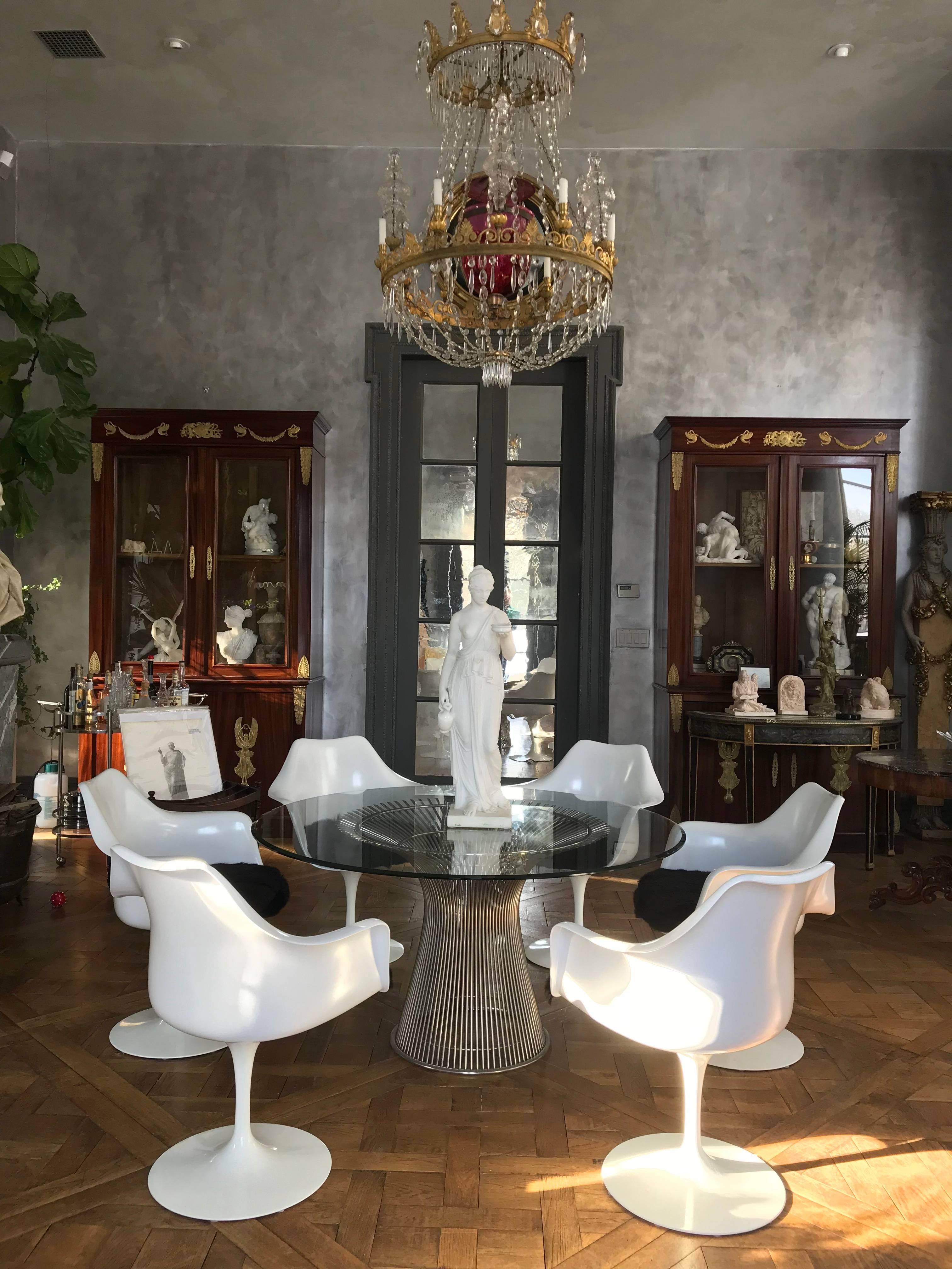 This elegant dining table was designed by Warren Platner for Knoll. 
It has a chrome cage design base and a bevelled glass top that can be replaced to accommodate a larger size top.
