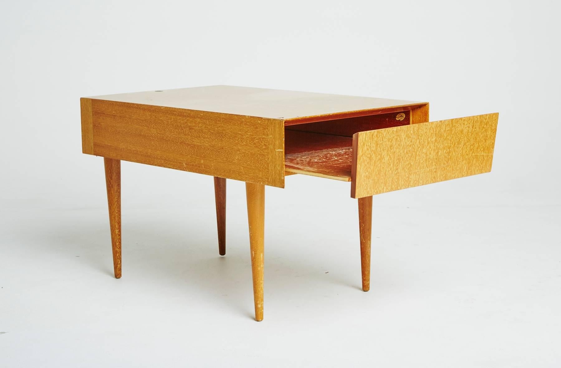 This Mid-Century Modern table by Paul Laszlo is the perfect side table, end table, occasional table, tea table, or nightstand. With tapering legs and a single drawer tabletop, this light mahogany table is a diverse piece of furniture. 

Perfectly