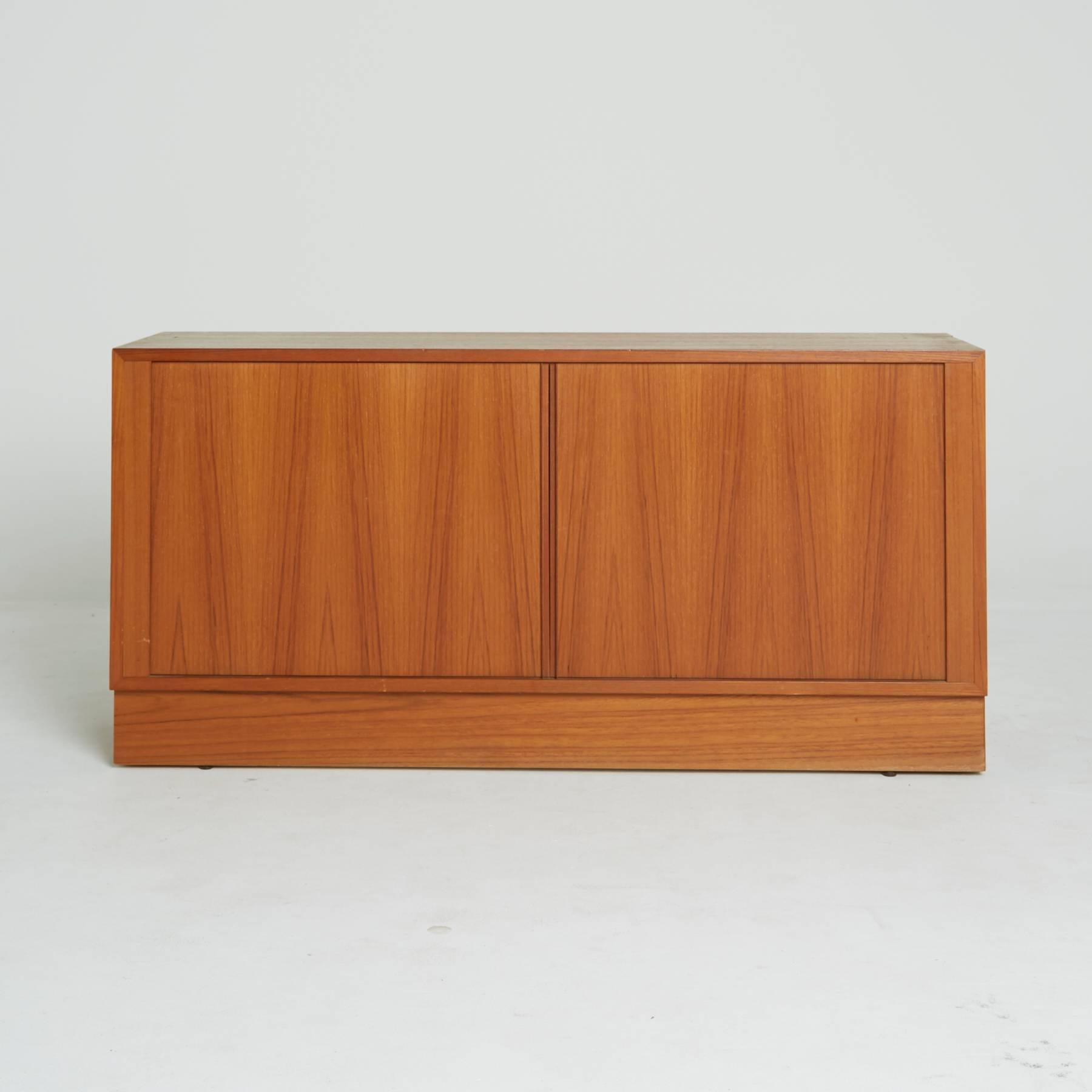 Compact in size, this perfect Danish modern sideboard is dynamic in its use, fitting perfectly where other other credenzas may overpower. Its beautiful teak construction displays an elongated zig zag pattern in the wood grain. The tambour doors
