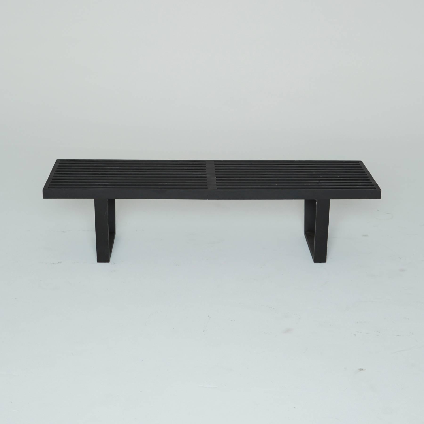 One of the most dynamic designs of mid century furniture, created by George Nelson for Herman Miller. This black lacquered wood bench has a slatted surface and two supportive trapezoids that create the stylish legs. 

This versatile item can be