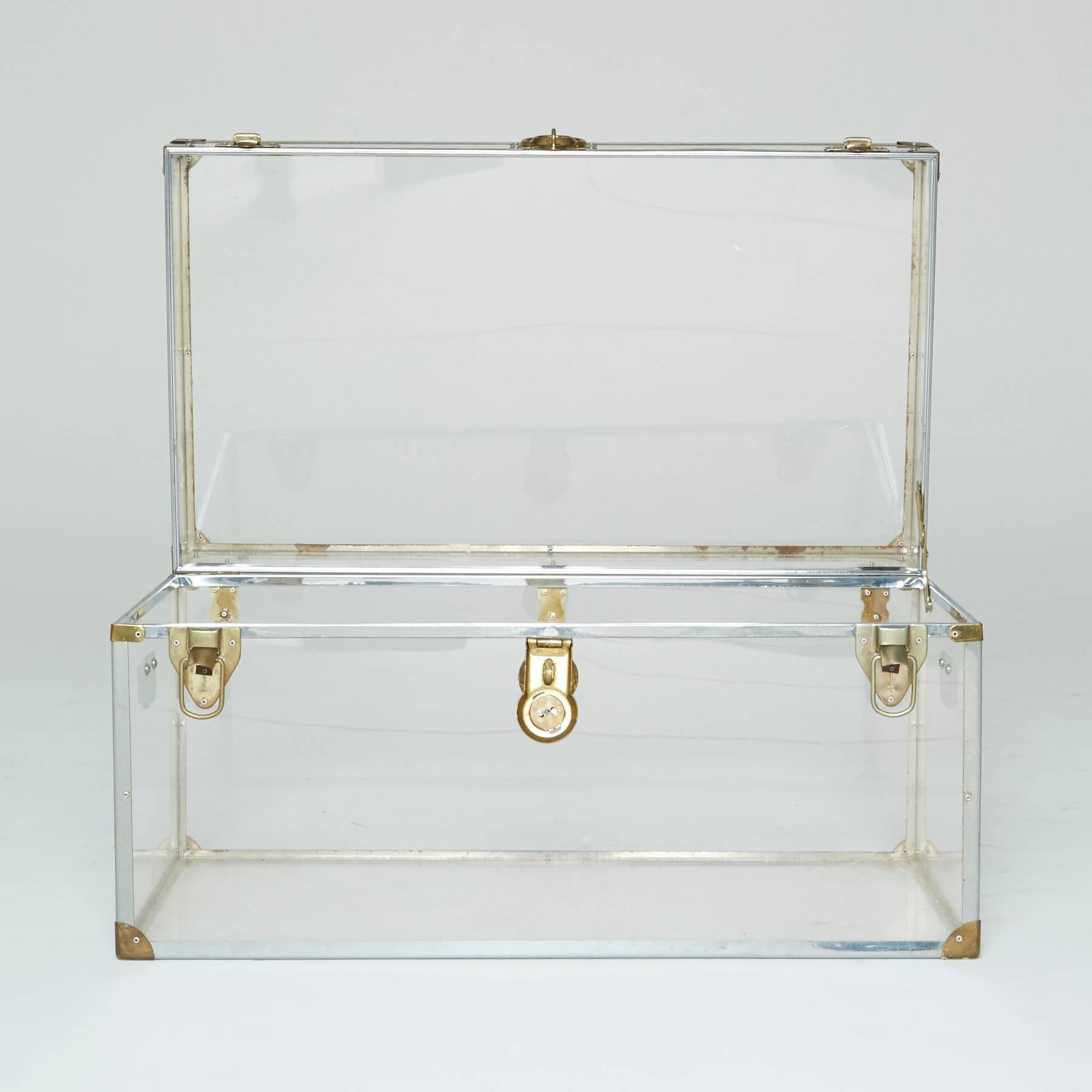 It just doesn't get any cooler than this vintage Lucite trunk. Brass hardware ornaments the corners, provides handles on the sides, and a three locking clasps on across the front. The trunk hails from the transparent trends of the 1960s and 1970s,