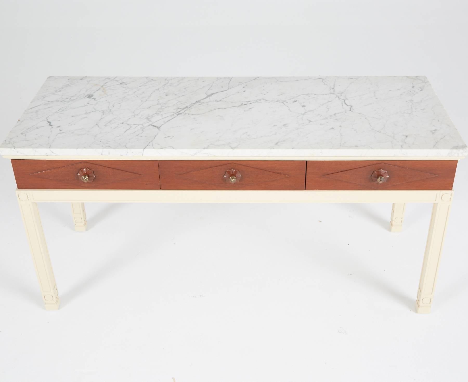 A creation of Grosfeld House, circa 1940s, renowned for classic elegance and Hollywood Regency. Recently restored walnut body of the table boasts a lusciously lacquered cream-colored frame and three natural wood drawers with decorative pulls.