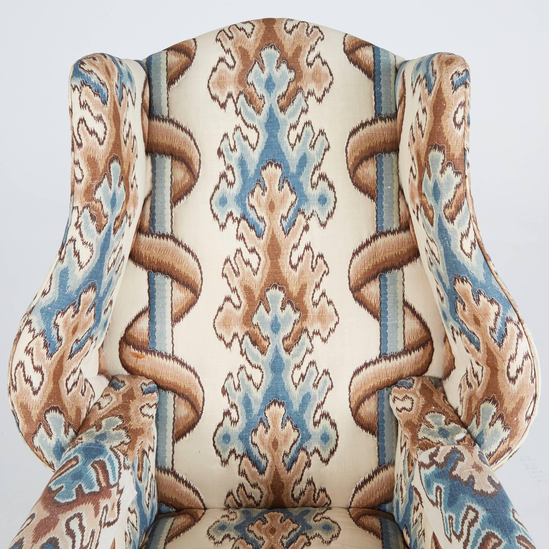 This armchair was created in the style of Chippendale, Georgian, Edwardian, and English Rococo aesthetics. Elevated on mahogany legs, this regal chair features curvaceous arm rests and is upholstered in a blue, brown, and cream abstract print.

In
