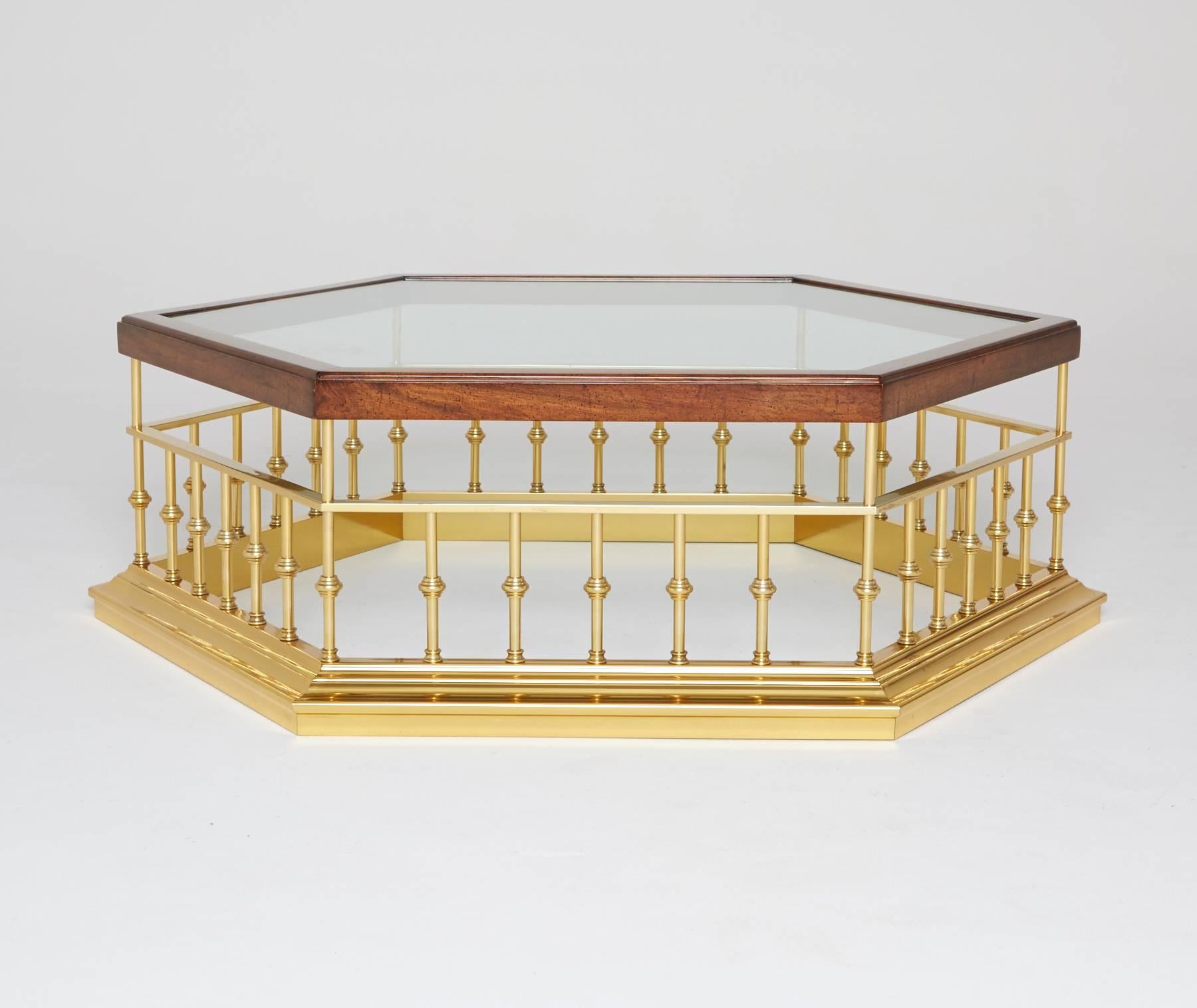 A hexagonal glass surface is inset into the walnut border, elevated by an ornamental balustrade brass frame. Perfect for use as a coffee table, cocktail table, or even as a display platform. 

Our adoration for the hexagon is deeply rooted: From