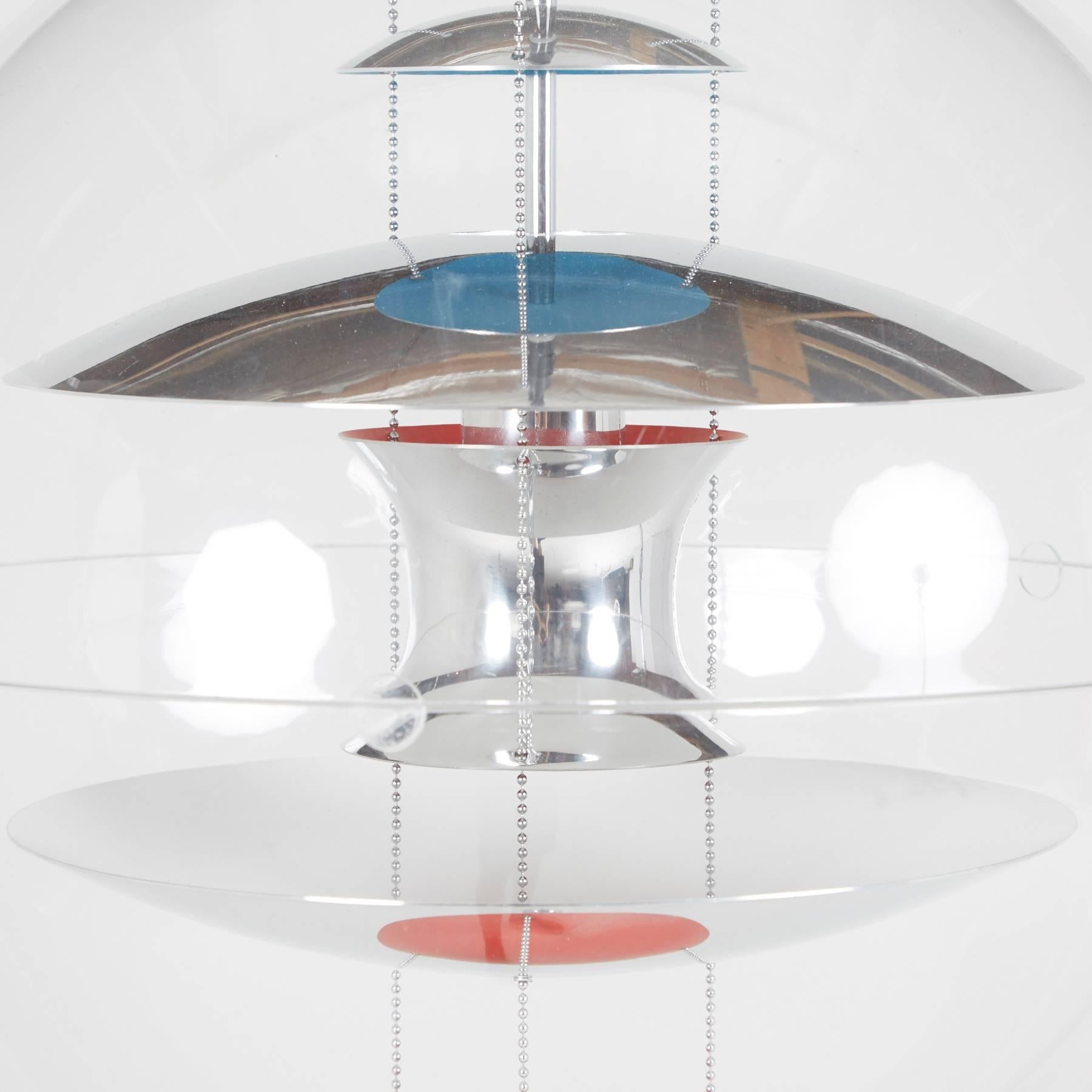 An incredible 1969 design by Verner Panton, this acrylic globe encompasses five curved reflectors suspended through the center - three chrome, one red, the other blue. With Panton's phenomenal use of color, shapes, and space, the breadth of this