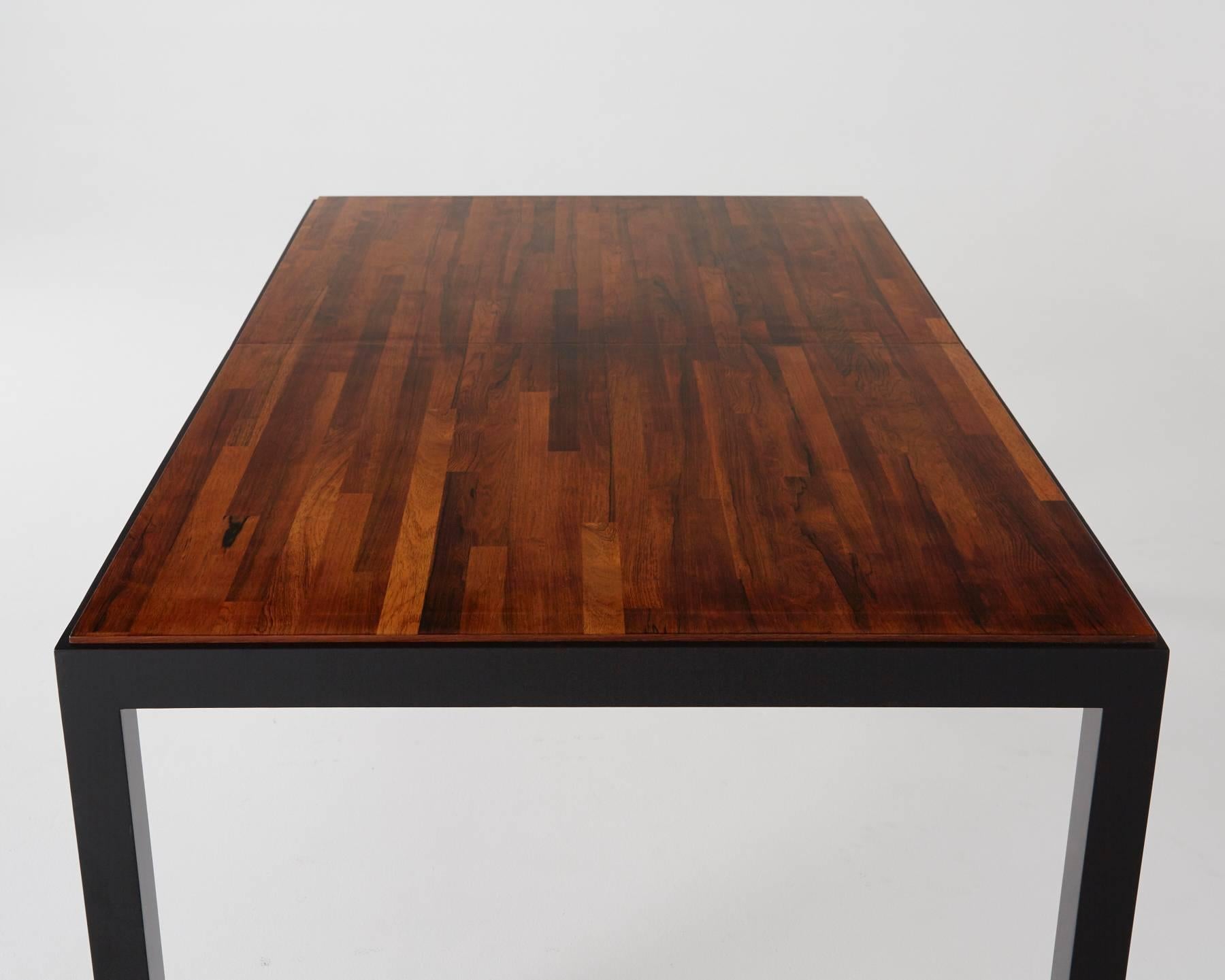 This beautifully restored dining table from Milo Baughman for Directional features strips of highly grained woods in various finishes creating contrasting lines for a spectacular effect. 

In excellent restored condition, the table is missing its