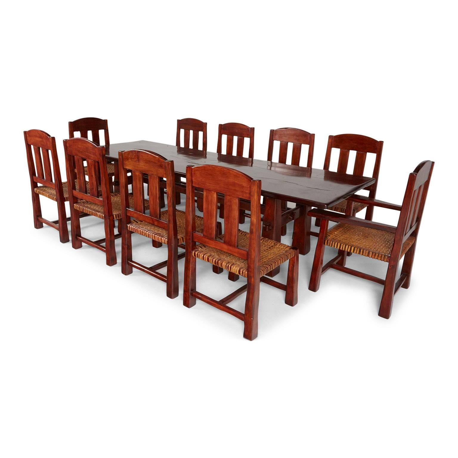 Expansive, great proportioned three plank trestle table and ten chairs made from Algarrobo wood from Argentina, designed by Larry Pearson and Ricardo Paz for Arte Etnico. This set was featured in the book "Rustic Home" by Ralph Kylloe,