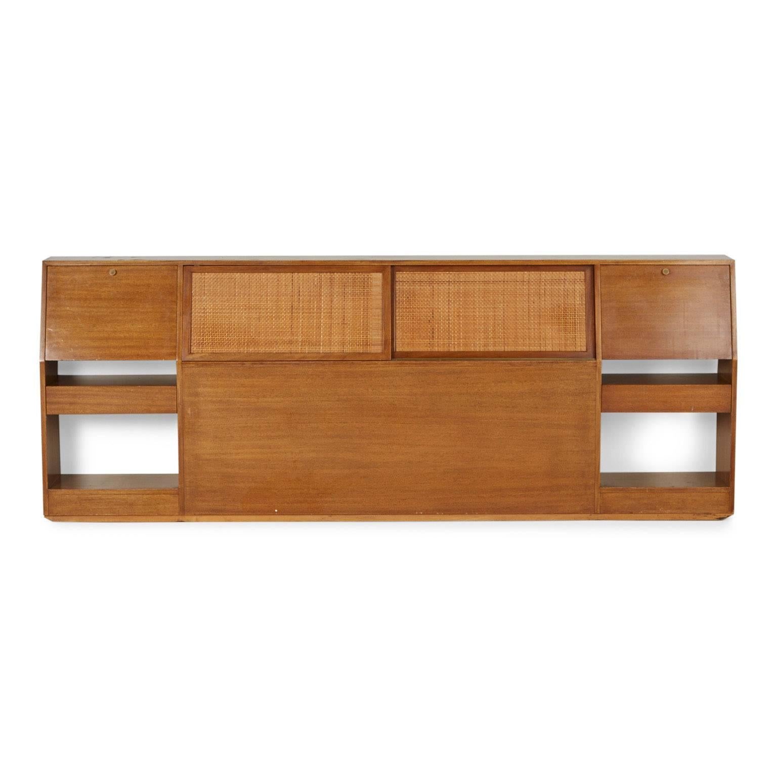 Designed by Harvey Probber, this sleek and functional Mid-Century Modern headboard features cane details and multiple opportunities for storage. Probber label affixed to a drawer interior.

 The neutral, clean finish would be a great addition to a