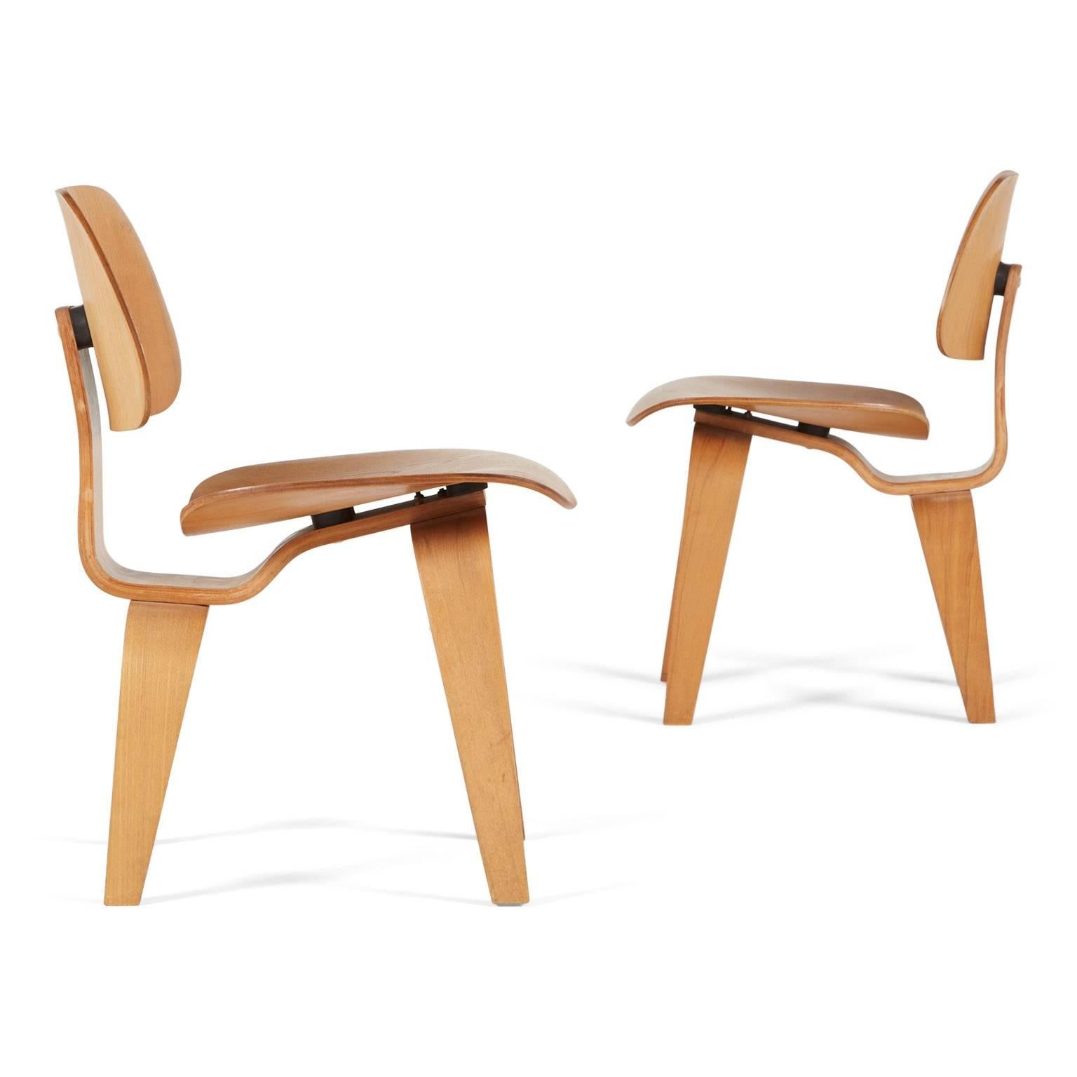 This pair of early example DCW's feature the 5-2-5 screw configuration as well as original three-part Evans labels. 

Evans Products Company manufactured The Eames molded plywood chairs from 1946 through 1949. Thereafter Herman Miller took over
